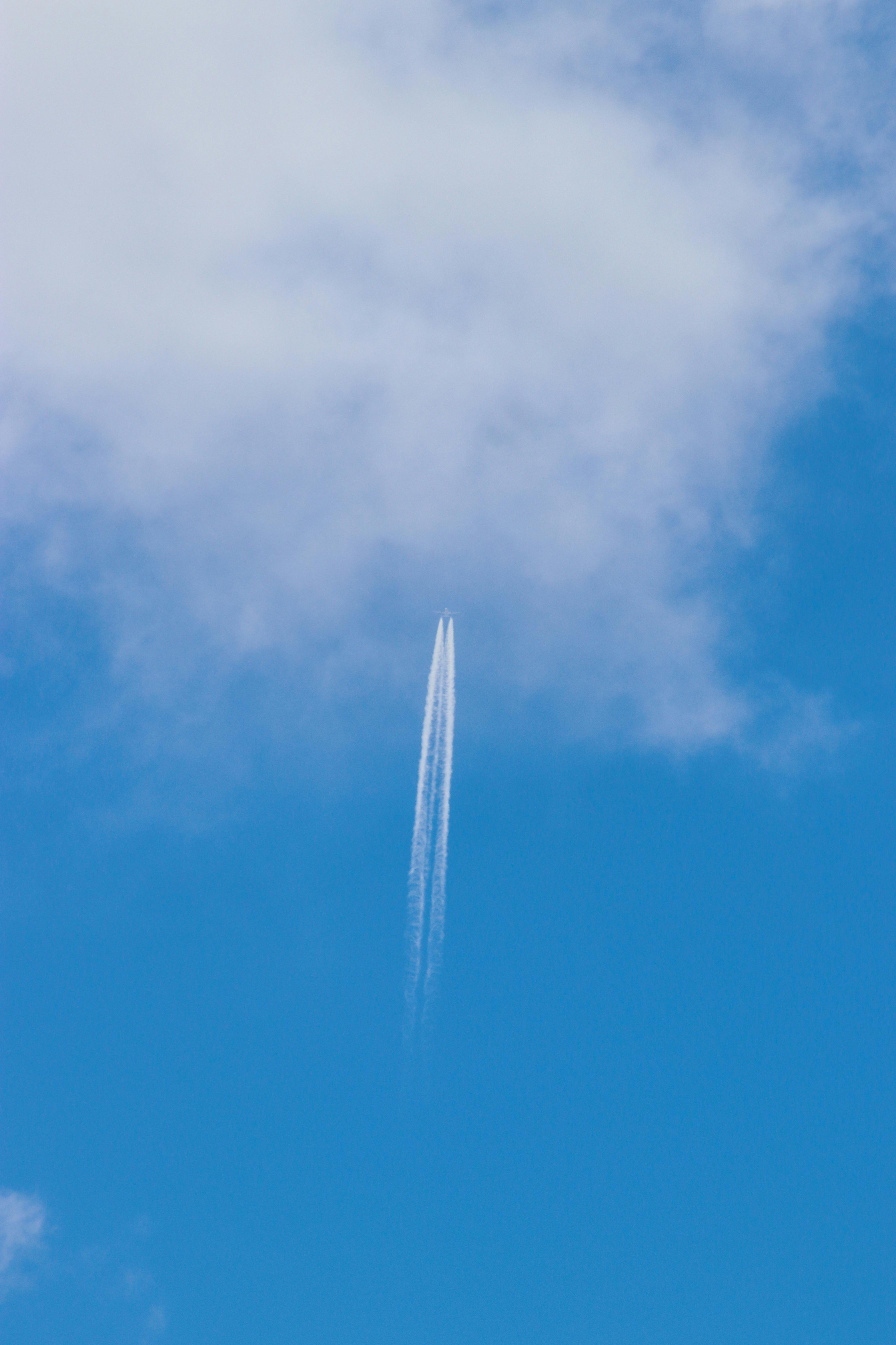 無料 澄み切った青空と雲を背景に飛行機雲を残します。 写真素材