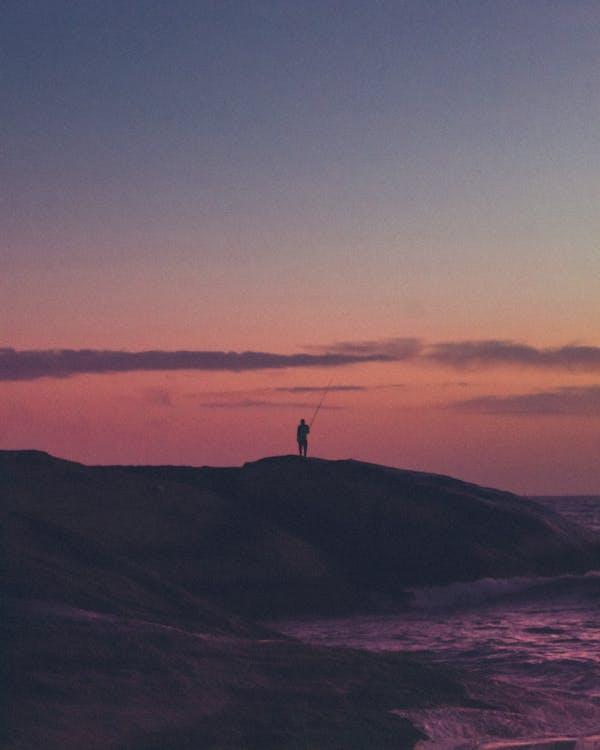 Person standing on an island during Sunset · Free Stock Photo