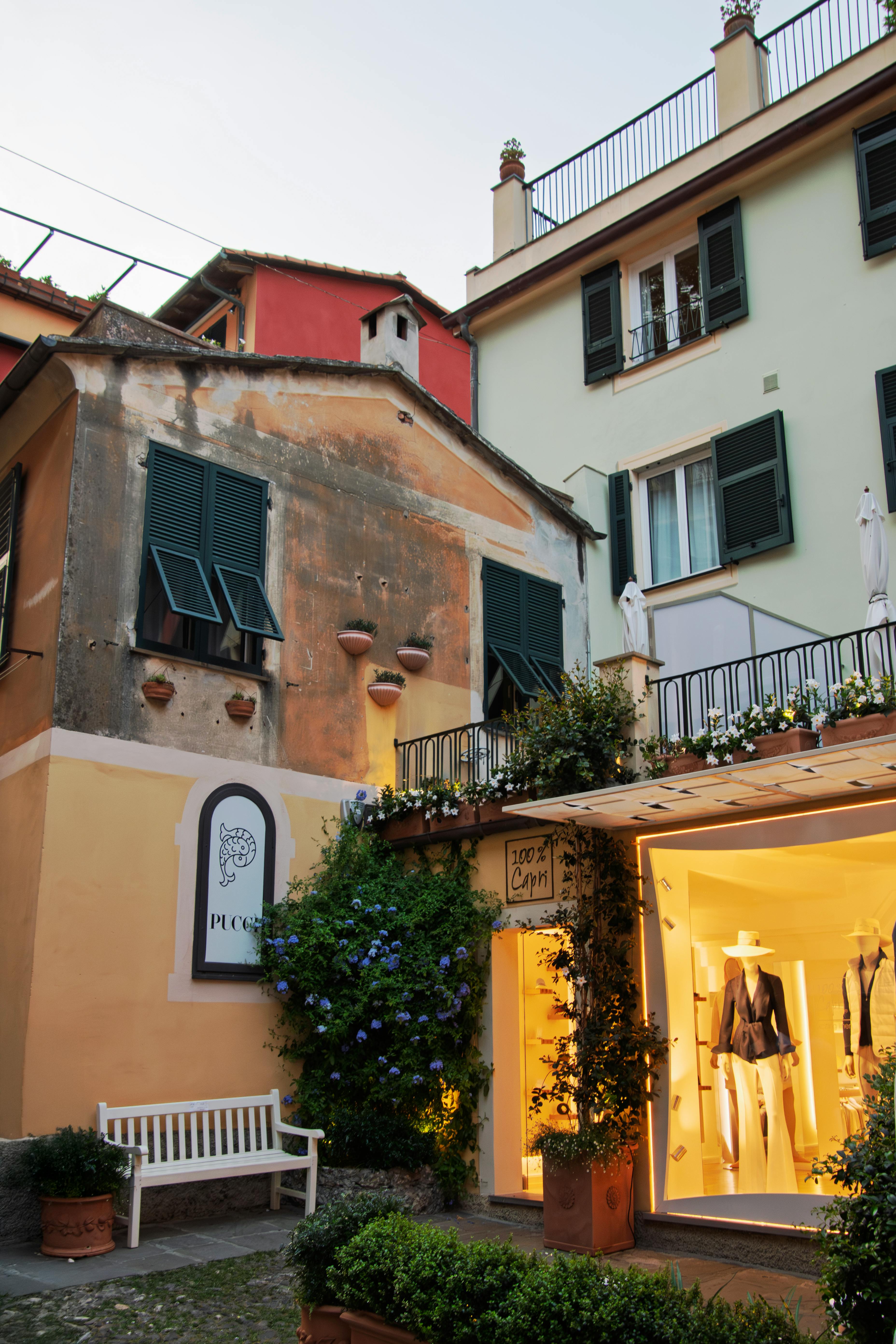 Gratis Oplev de fortryllende gader i Portofino, Italien i skumringen, med malerisk arkitektur og livlige butiksfacader. Lagerfoto