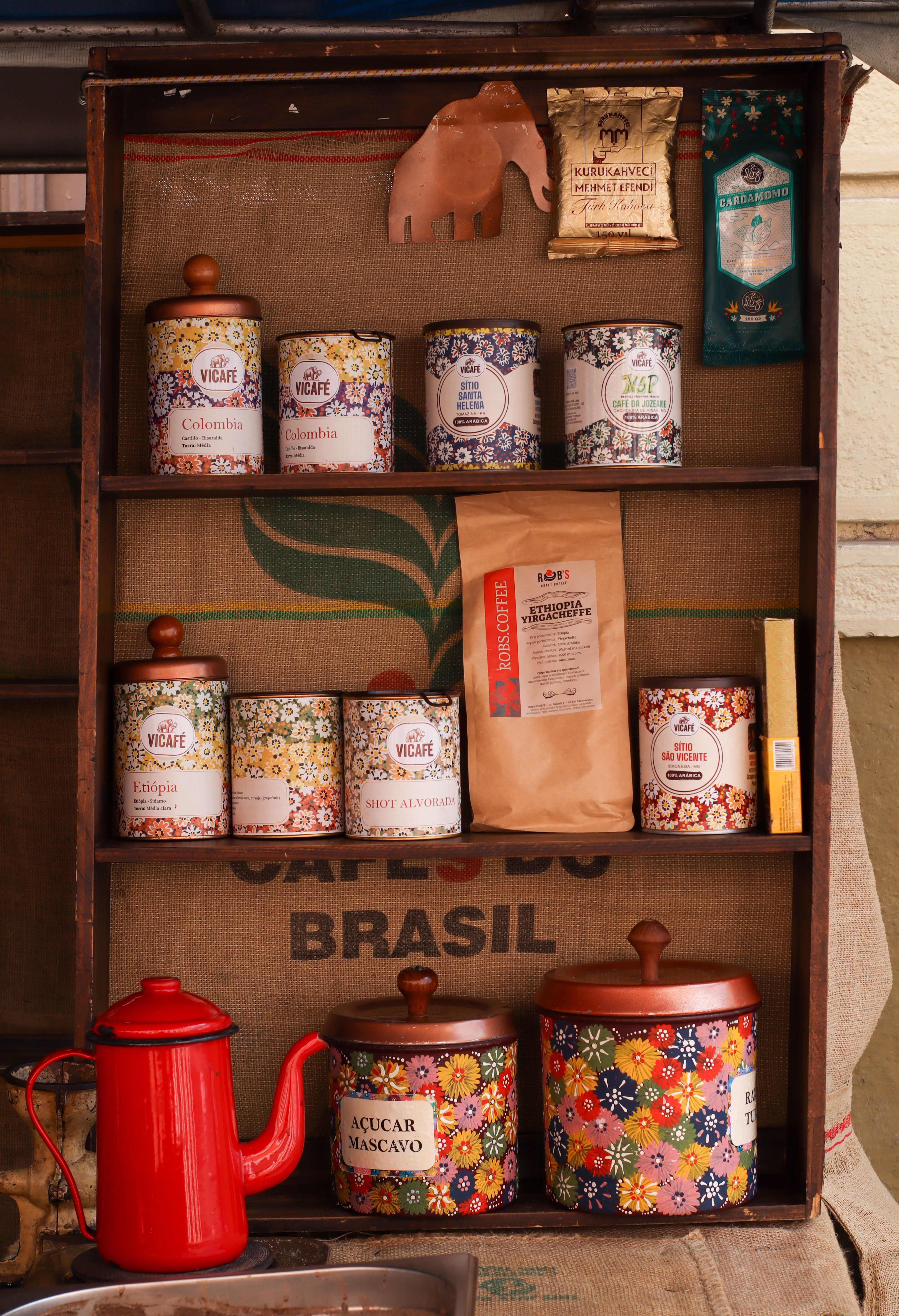 Free Colorful vintage coffee and tea storage tins on a shelf with a red kettle. Stock Photo