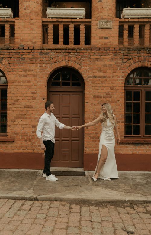 Free Stylish couple in love holding hands in front of a rustic brick wall. Stock Photo