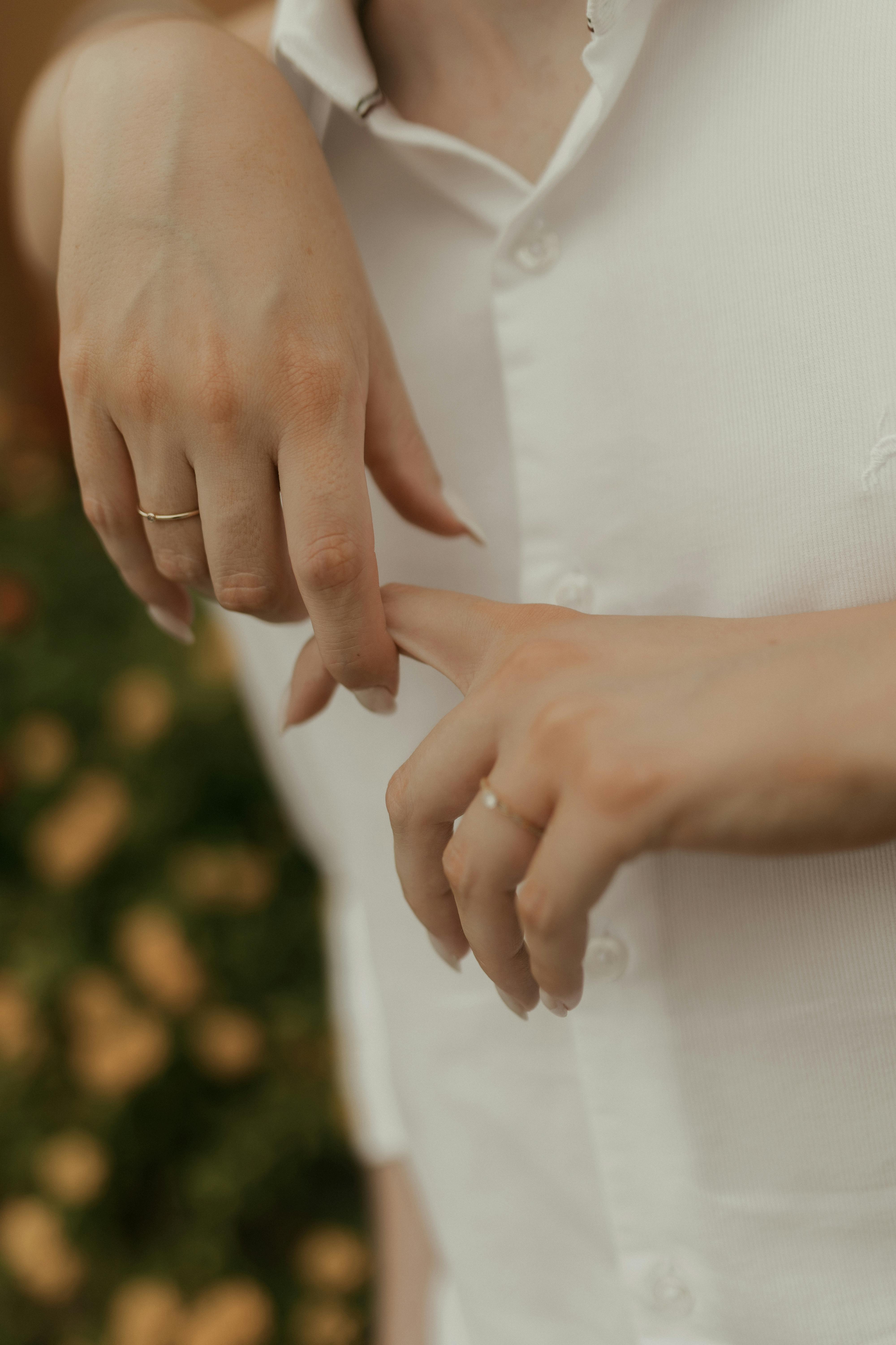 Miễn phí Hình ảnh cận cảnh đôi bàn tay đeo nhẫn đính hôn trong khung cảnh khu vườn thanh bình, thể hiện tình yêu và sự cam kết. Ảnh lưu trữ