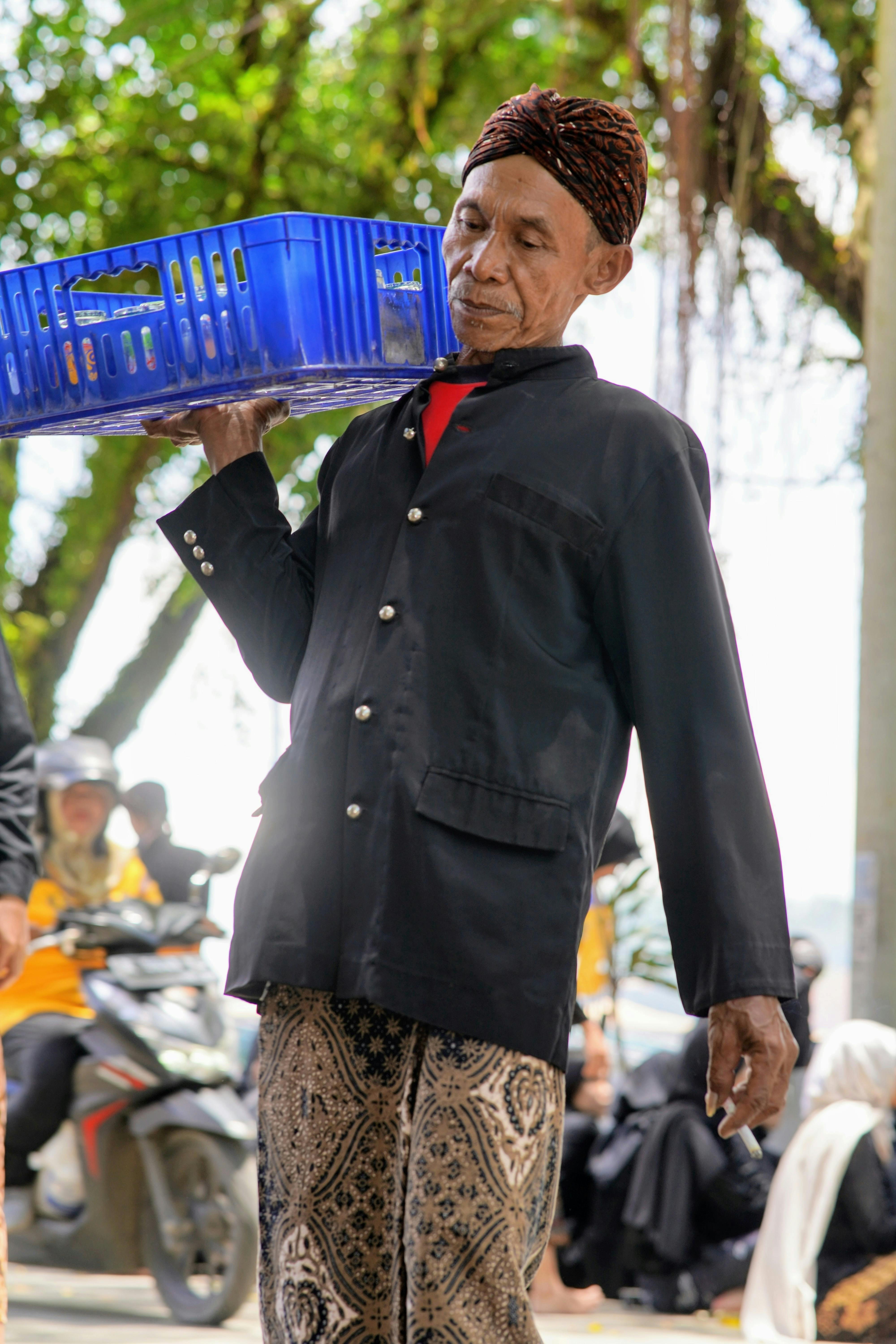 Gratis Pedagang lanjut usia membawa barang dagangan di pasar yang ramai di Jawa Tengah, Indonesia. Foto Stok