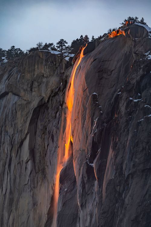 Free Horsetail Fall in Yosemite illuminated by sunset, resembling flowing lava. Stock Photo