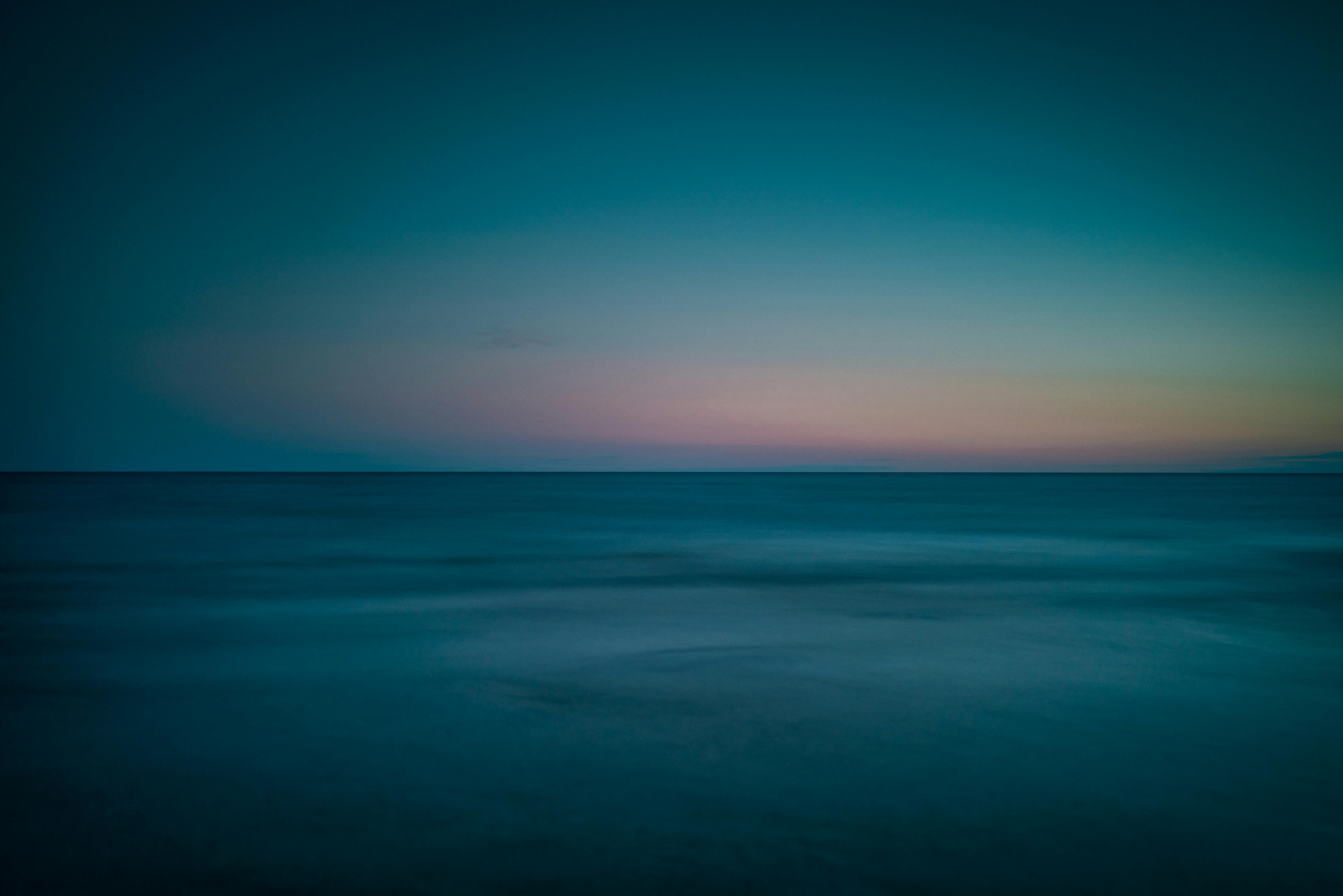 Gratis Fredelig langtidseksponeringsbillede af solnedgangen ved Lake Ontario, der fremviser bløde nuancer af blå og lyserød. Lagerfoto