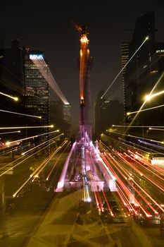 Dynamic nighttime capture of Angel de la Independencia with motion blur and street lights in Mexico City.