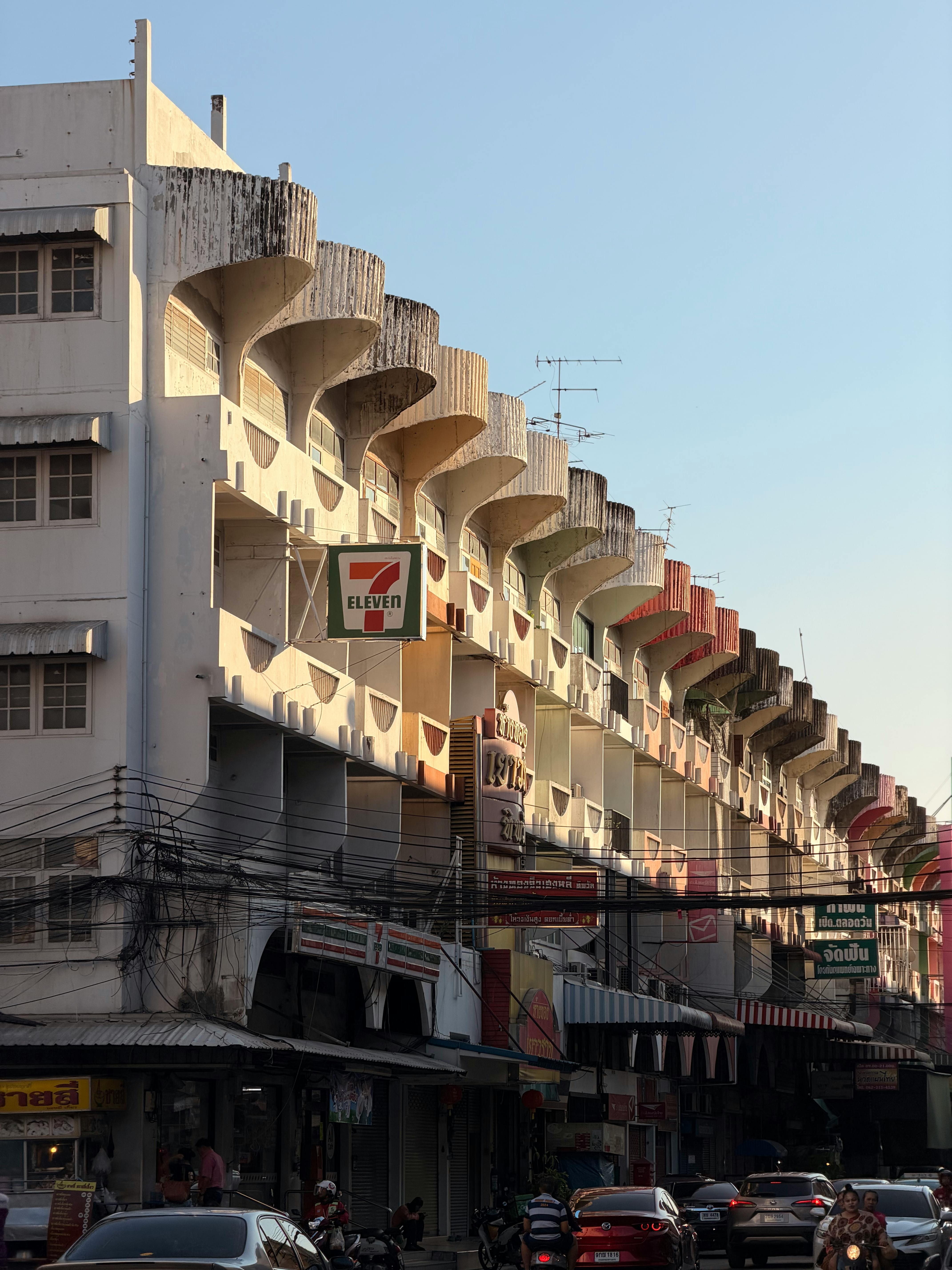 無料 特徴的な建築物や地元のお店、活気ある街並みを捉えた、太陽に照らされたバンコクの街路。 写真素材