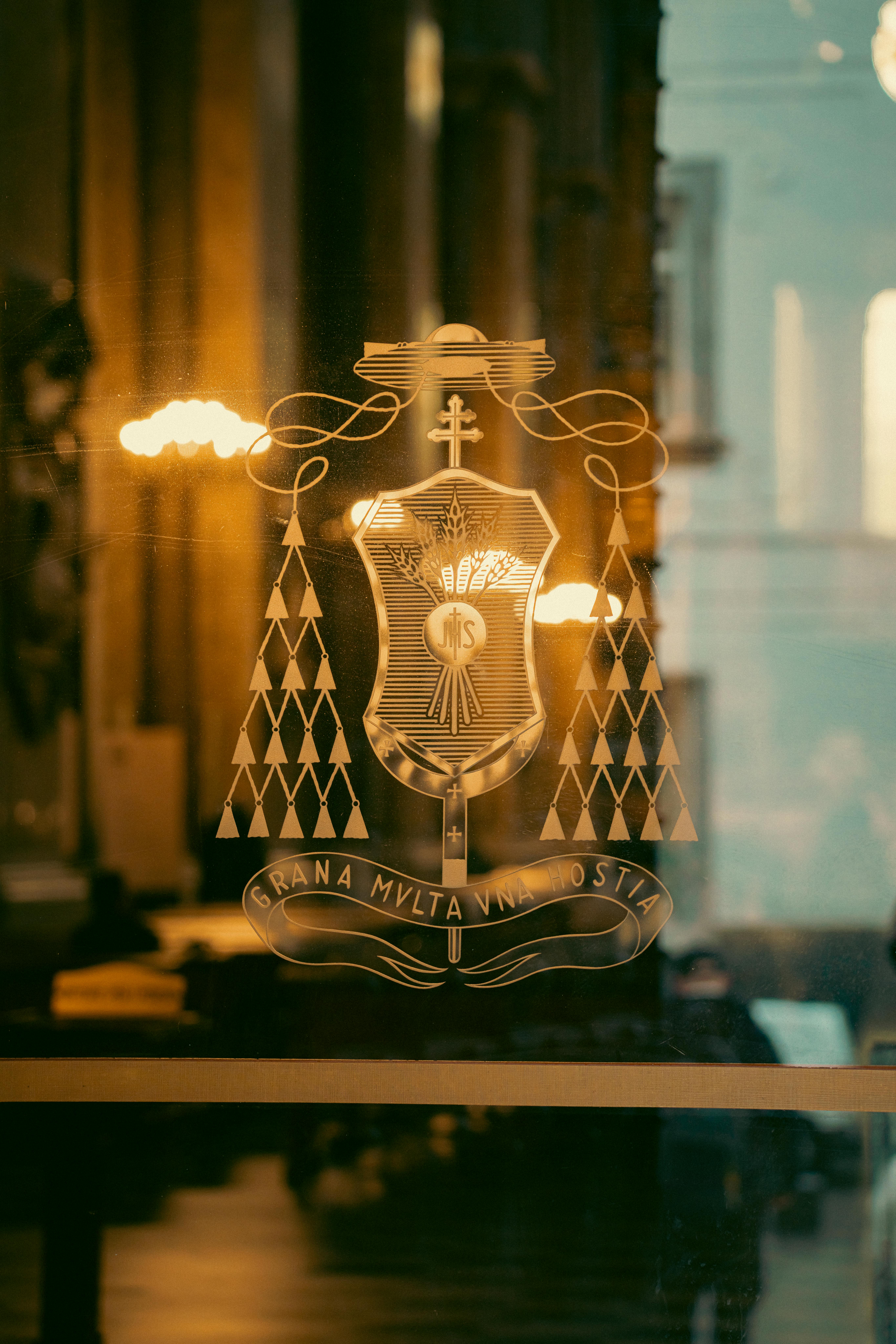Free A detailed view of a historic emblem on glass with warm lighting in Naples, Italy. Stock Photo