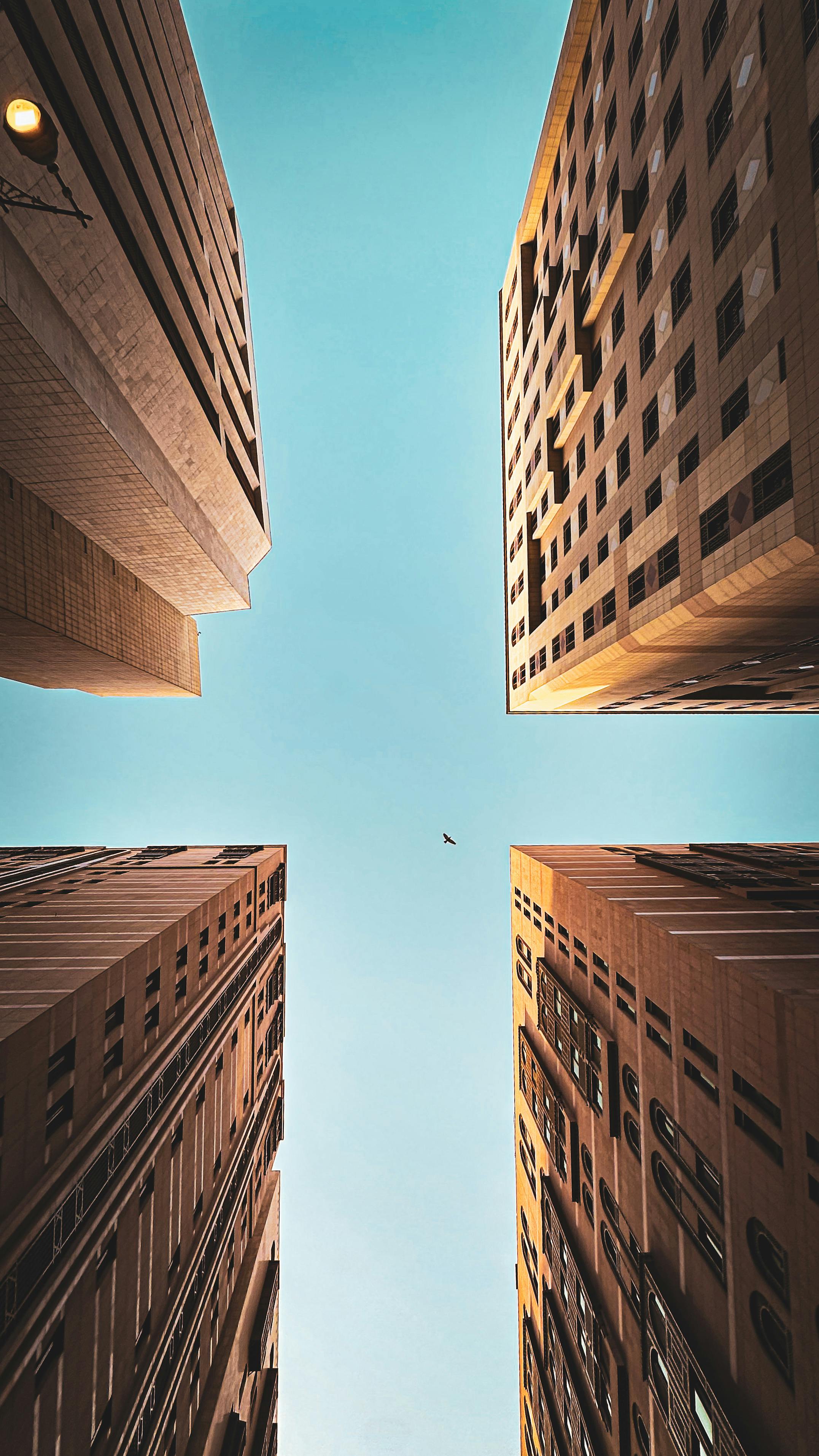 бесплатная Вид сверху на высотные здания, сливающиеся на фоне чистого голубого неба в Медине, Саудовская Аравия. Стоковое фото