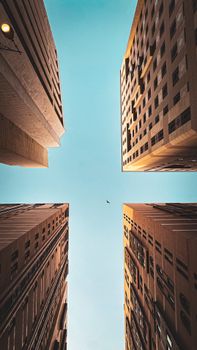 Upward view of tall buildings converging against a clear blue sky in Medina, Saudi Arabia.