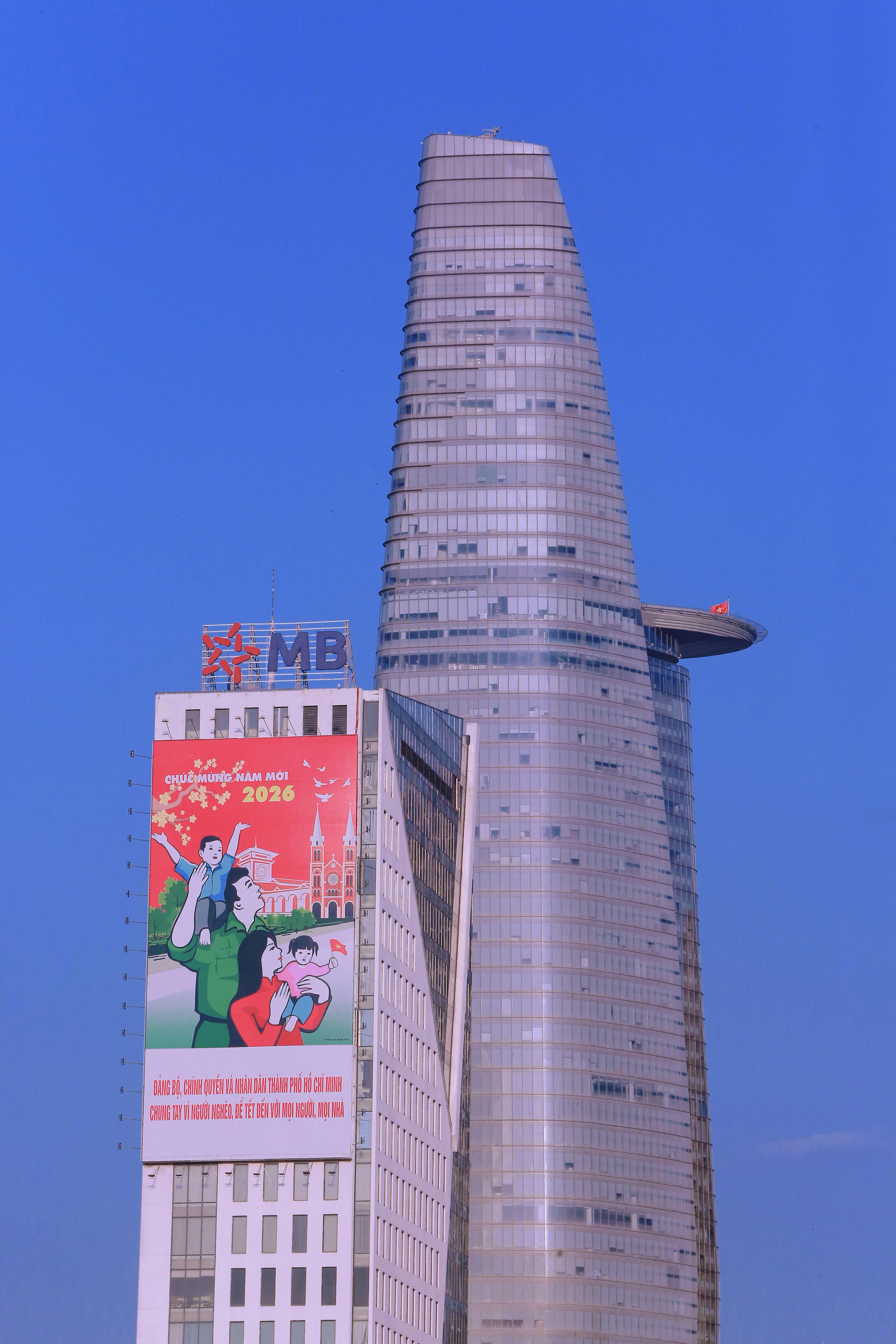 Free Modern skyscraper with colorful billboard in Ho Chi Minh City, Vietnam. Stock Photo