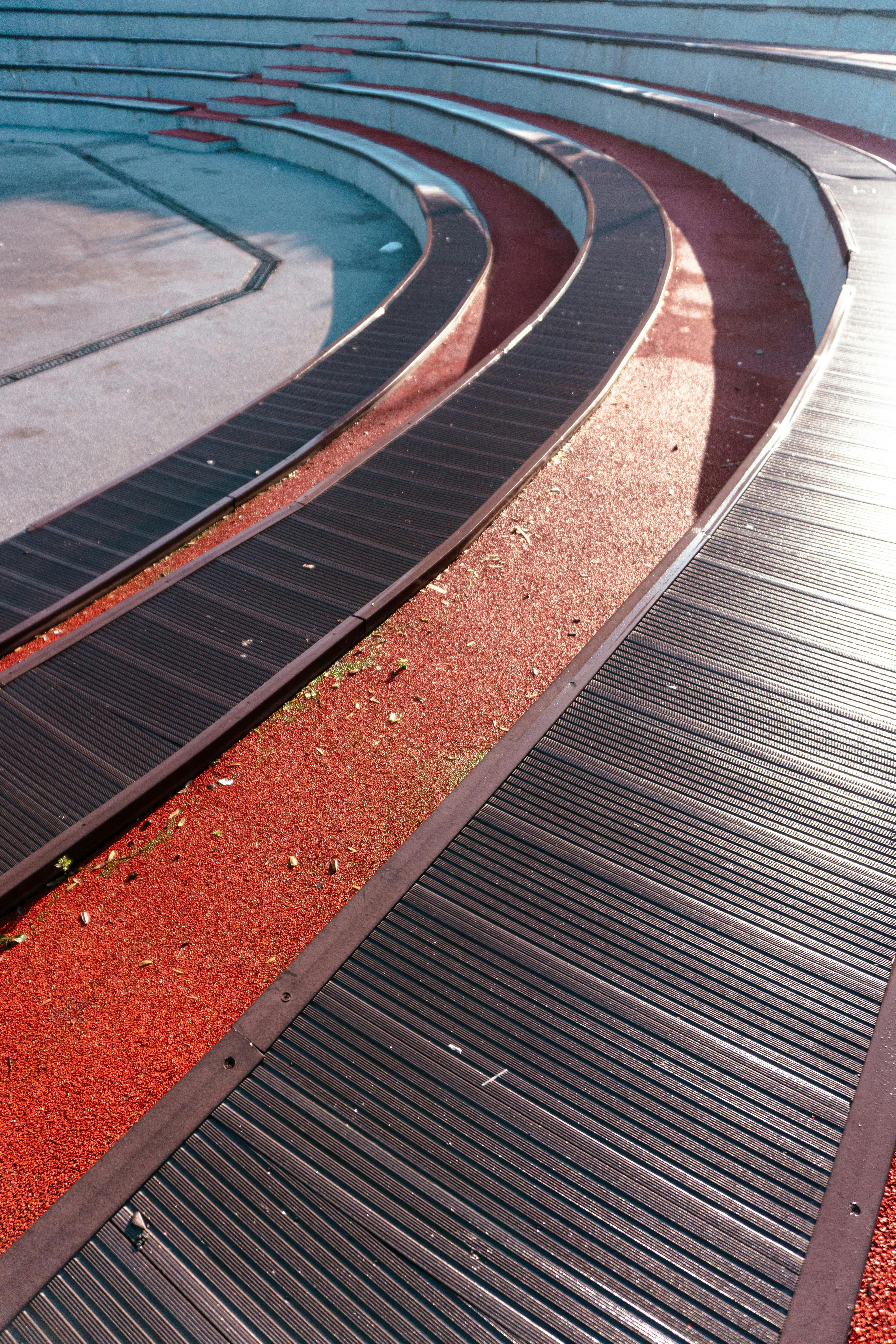 grátis Bancos de madeira curvados em um parque moderno de Istambul, com a luz do sol projetando sombras. Foto profissional