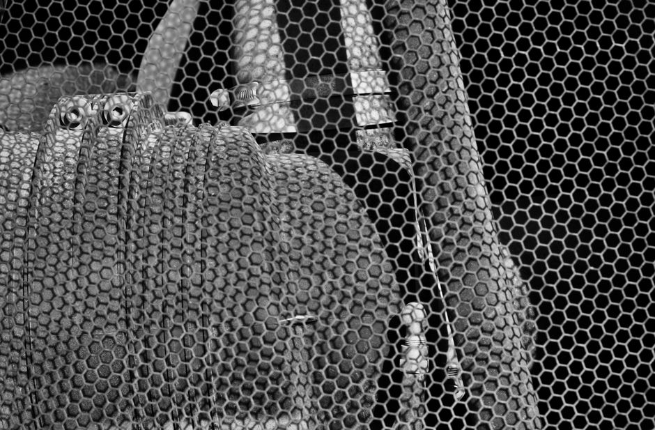 Abstract black and white photo of hexagonal patterned bags with a net overlay.