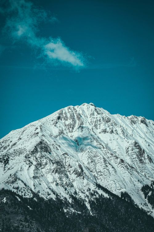 Free A stunning snow-covered mountain peak under a clear blue sky, showcasing winter's beauty. Stock Photo