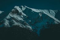 在凉爽的傍晚，于灯光映照下探索白雪覆盖的壮丽山峰，展现大自然的宁静之美