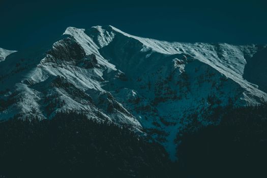 在凉爽的傍晚，于灯光映照下探索白雪覆盖的壮丽山峰，展现大自然的宁静之美