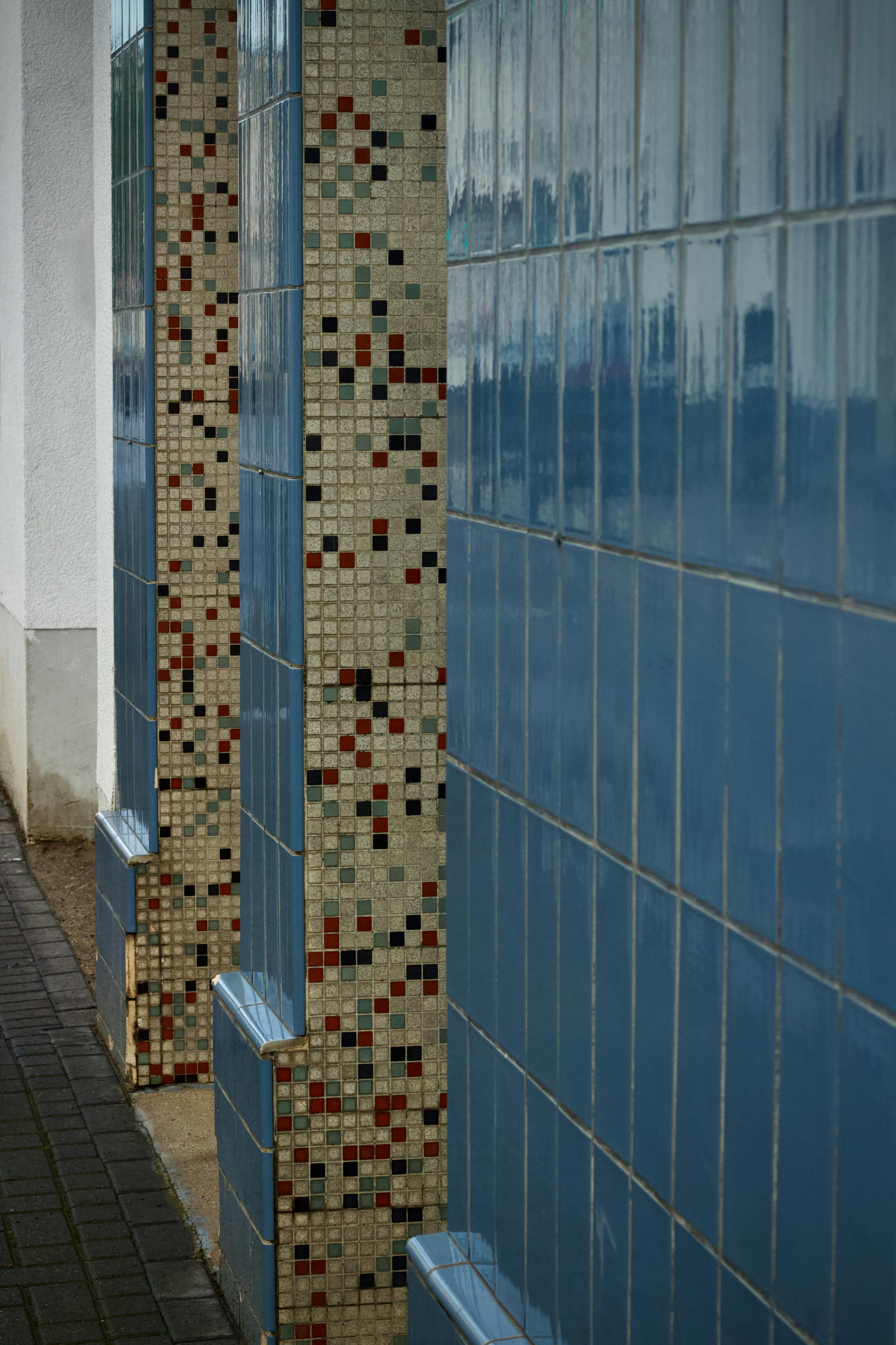 Free A vibrant display of blue and mosaic tiles on a building wall. Stock Photo