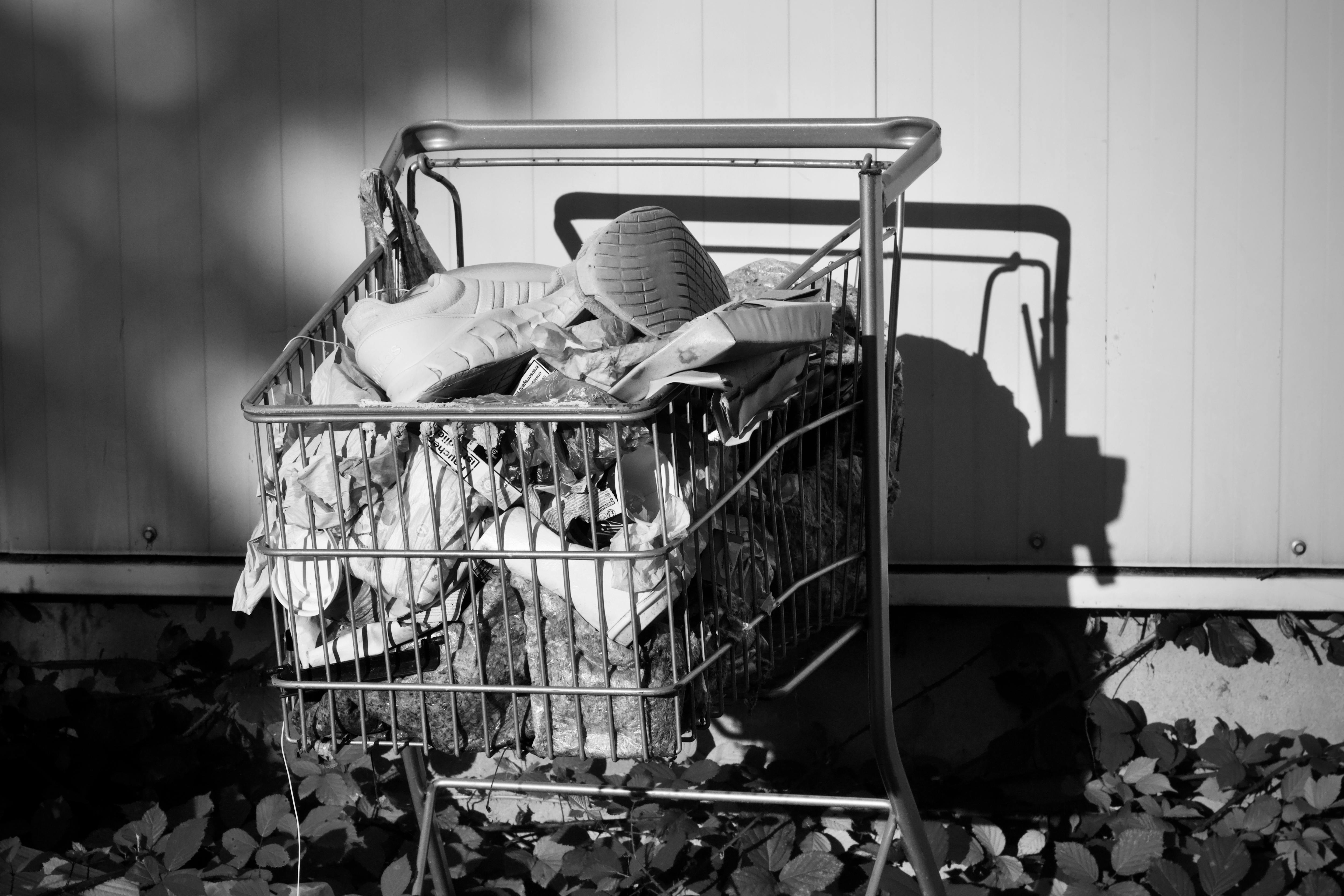 De franc Fotografia en blanc i negre d'un carretó de la compra abandonat ple de diversos objectes. Foto d'estoc