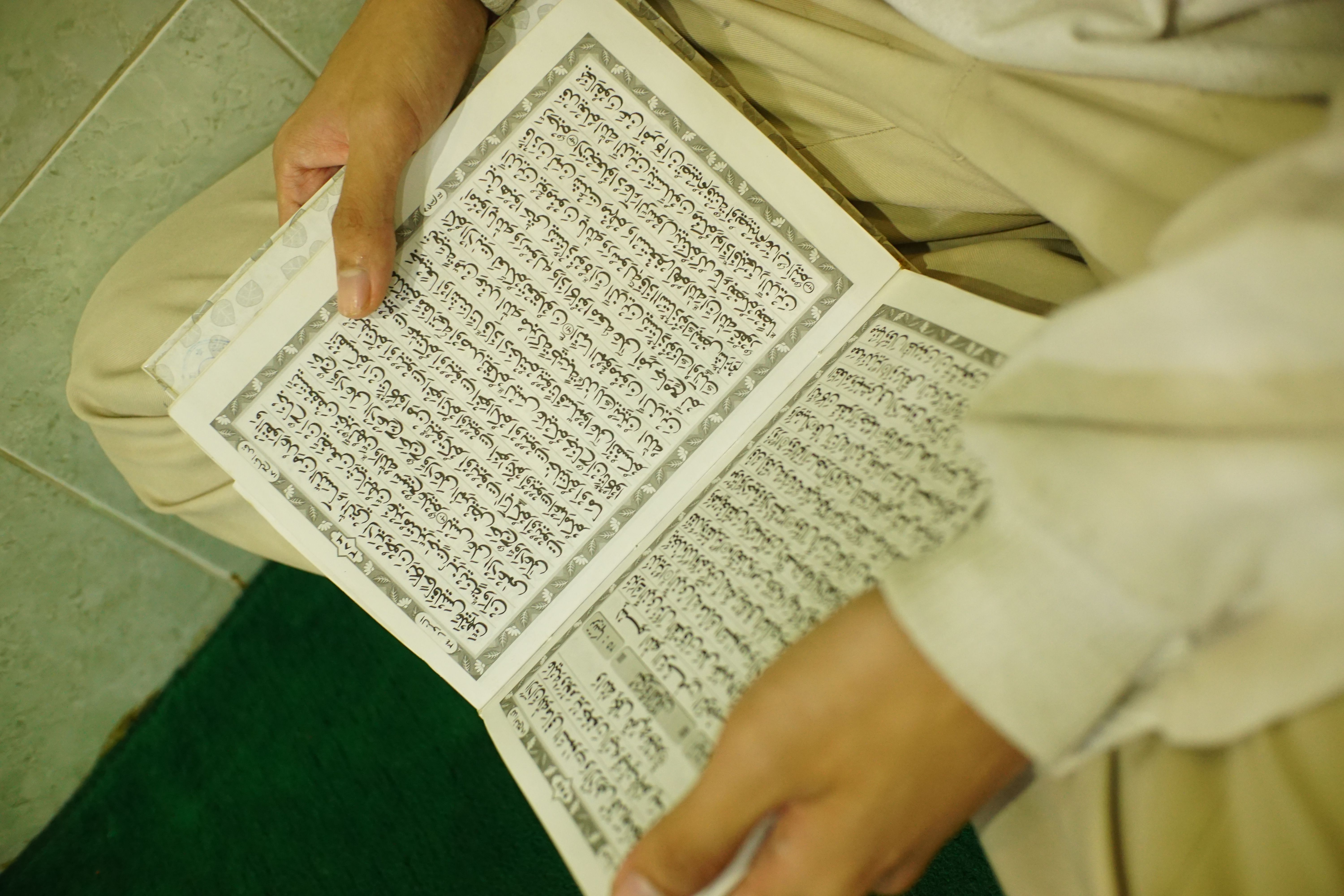 Person Reading Religious Text Indoors · Free Stock Photo