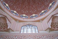 马来西亚的清真寺内部，美丽的错综复杂结构，与粉红色的圆顶天花板和彩色玻璃窗相映成趣