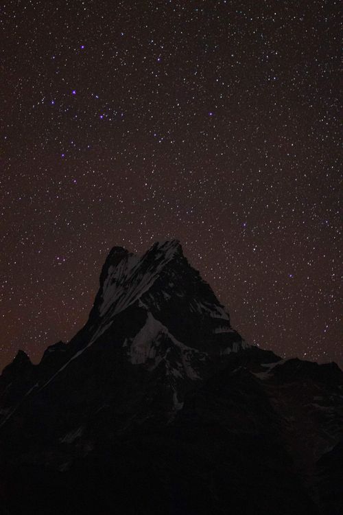 Free A stunning view of a mountain peak silhouetted against a star-studded night sky in Nepal. Stock Photo