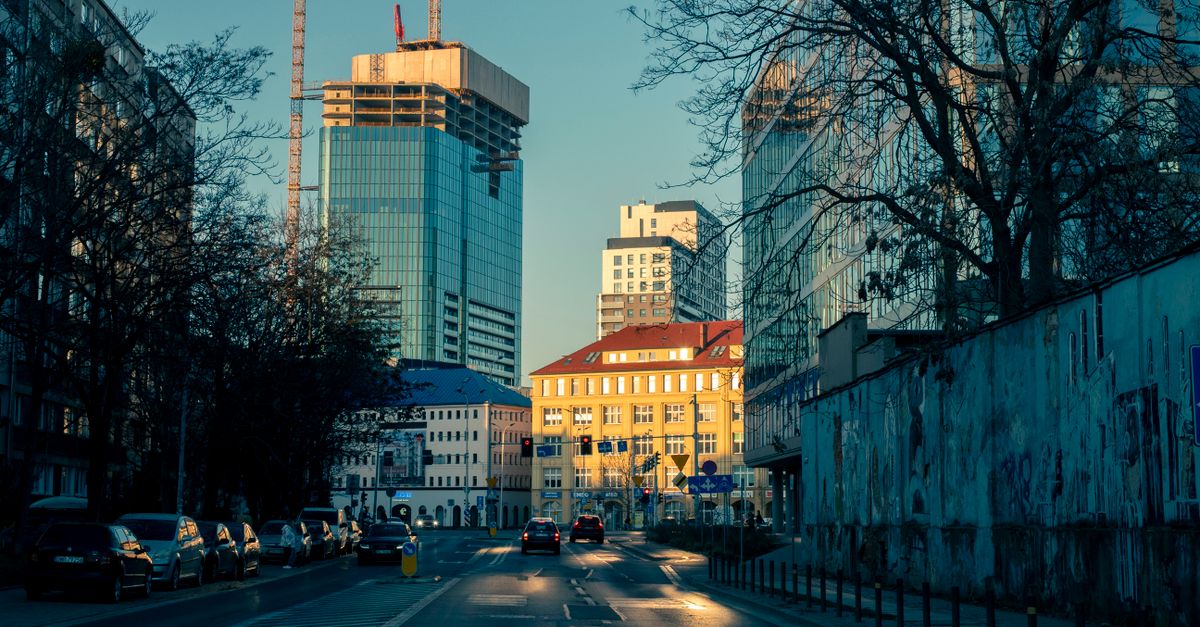 City street with skyscrapers and traffic in Wrocław, Poland, under a clear sky.