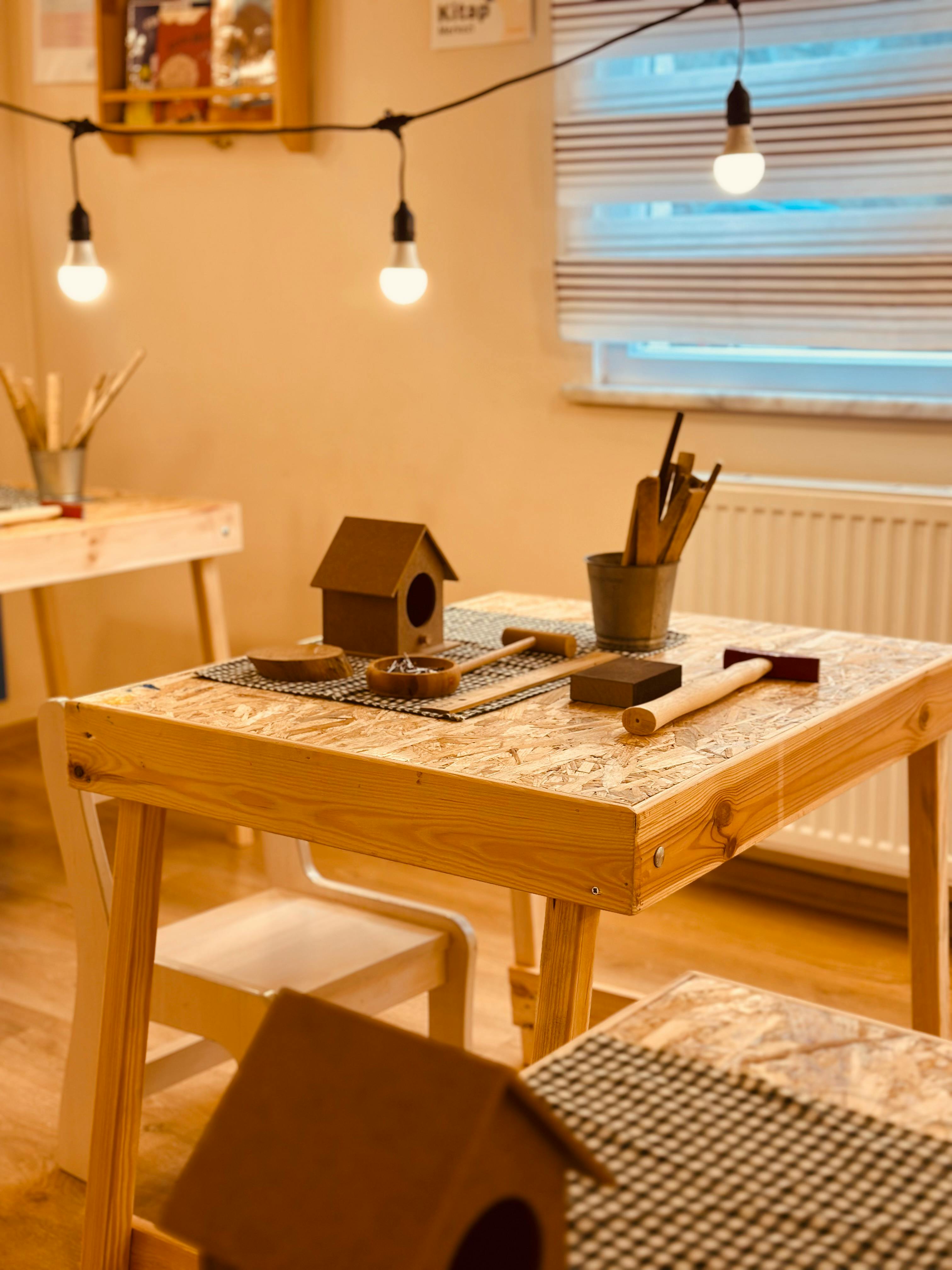 無料 木工道具や模型の鳥小屋を備えた温かみのある屋内クラフトコーナー。 写真素材