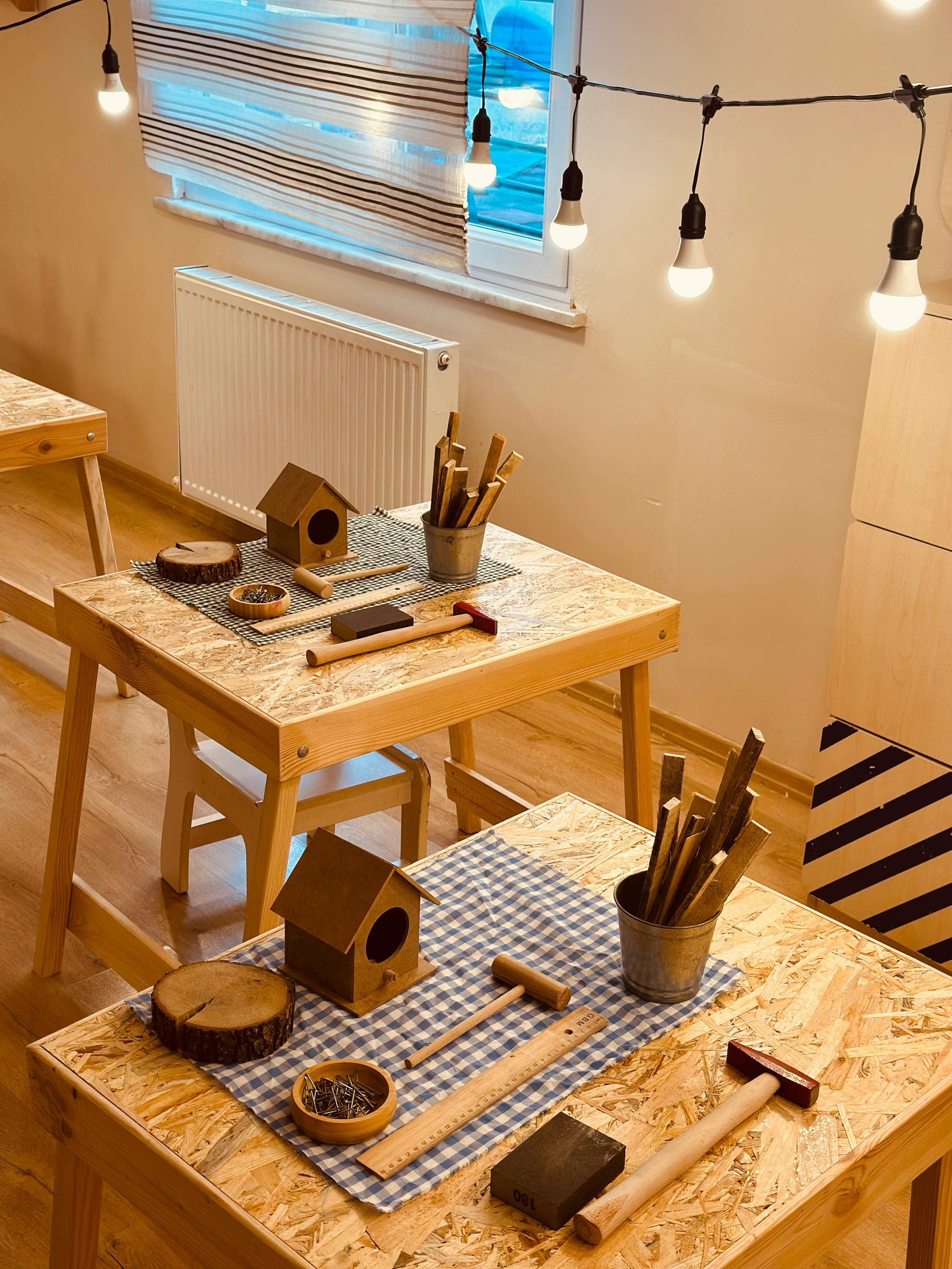 Gratis Varmt og indbydende hobbyrum med værktøj og træprojekter på borde. Lagerfoto