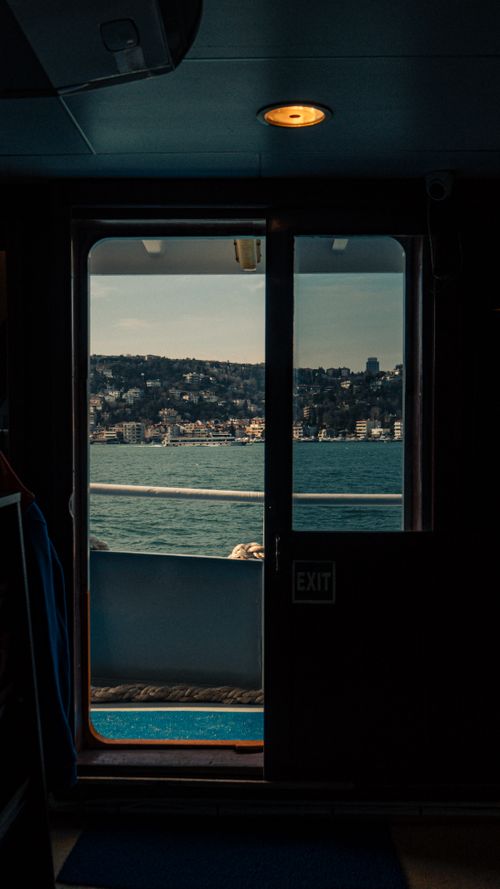 Free Dramatic view through ferry door features city skyline across water. Stock Photo