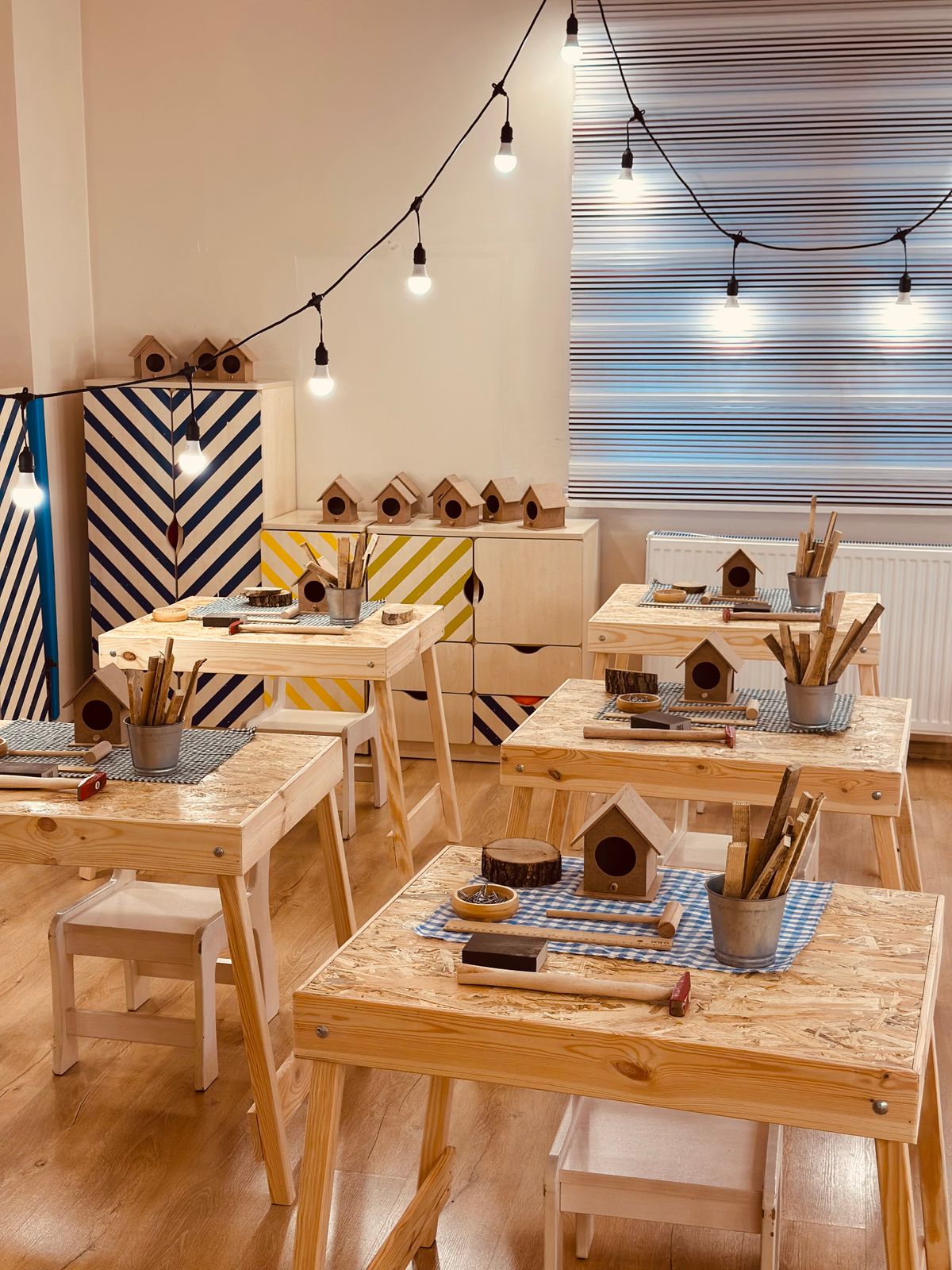 Wooden birdhouses lined up on workbenches ready for students to paint