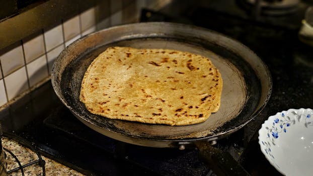 Close-up of a freshly cooked flatbread on a pan, showcasing rich texture and home-cooked warmth.