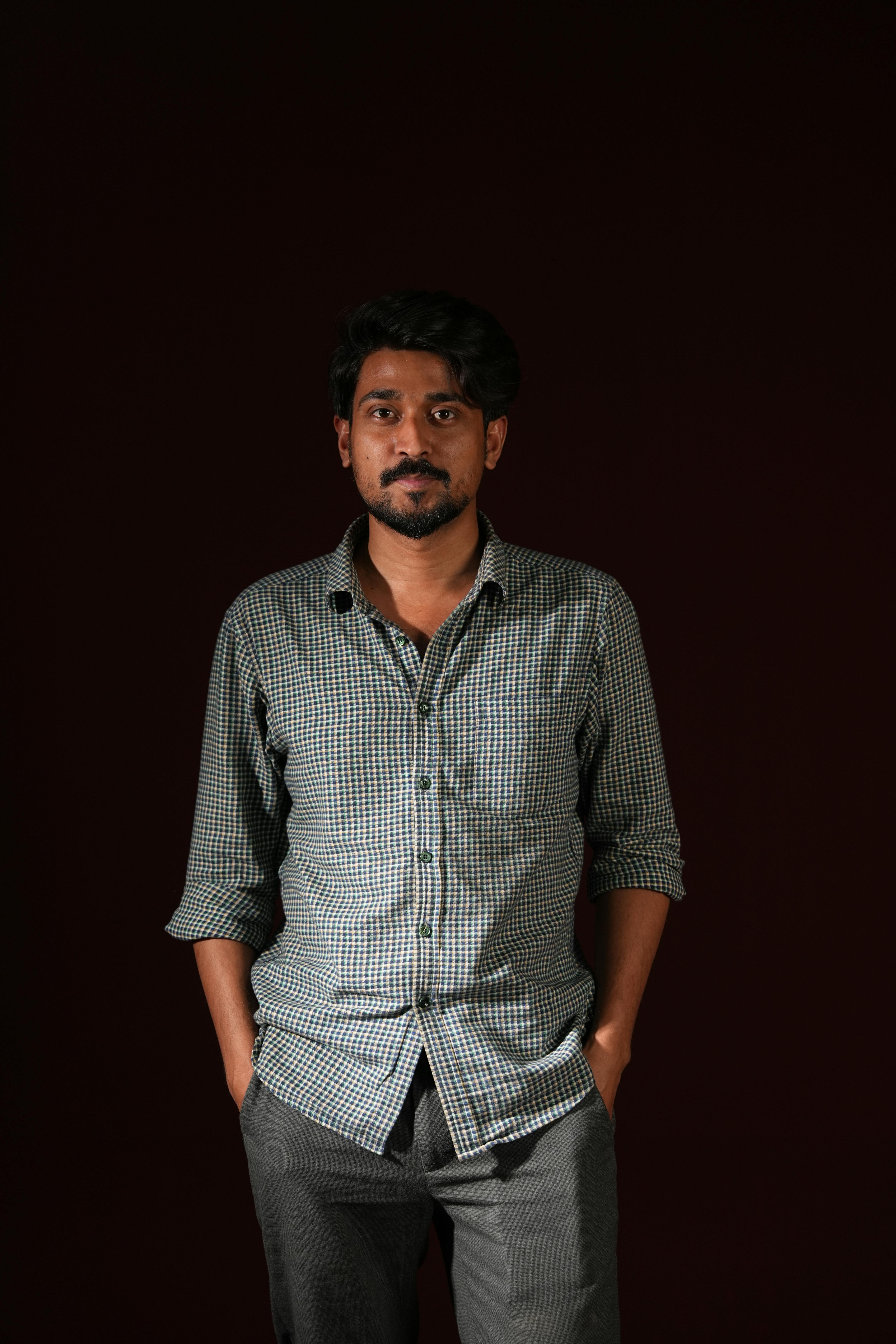 Gratis Potret seorang pria dewasa muda dengan pakaian kasual dan latar belakang gelap. Foto Stok