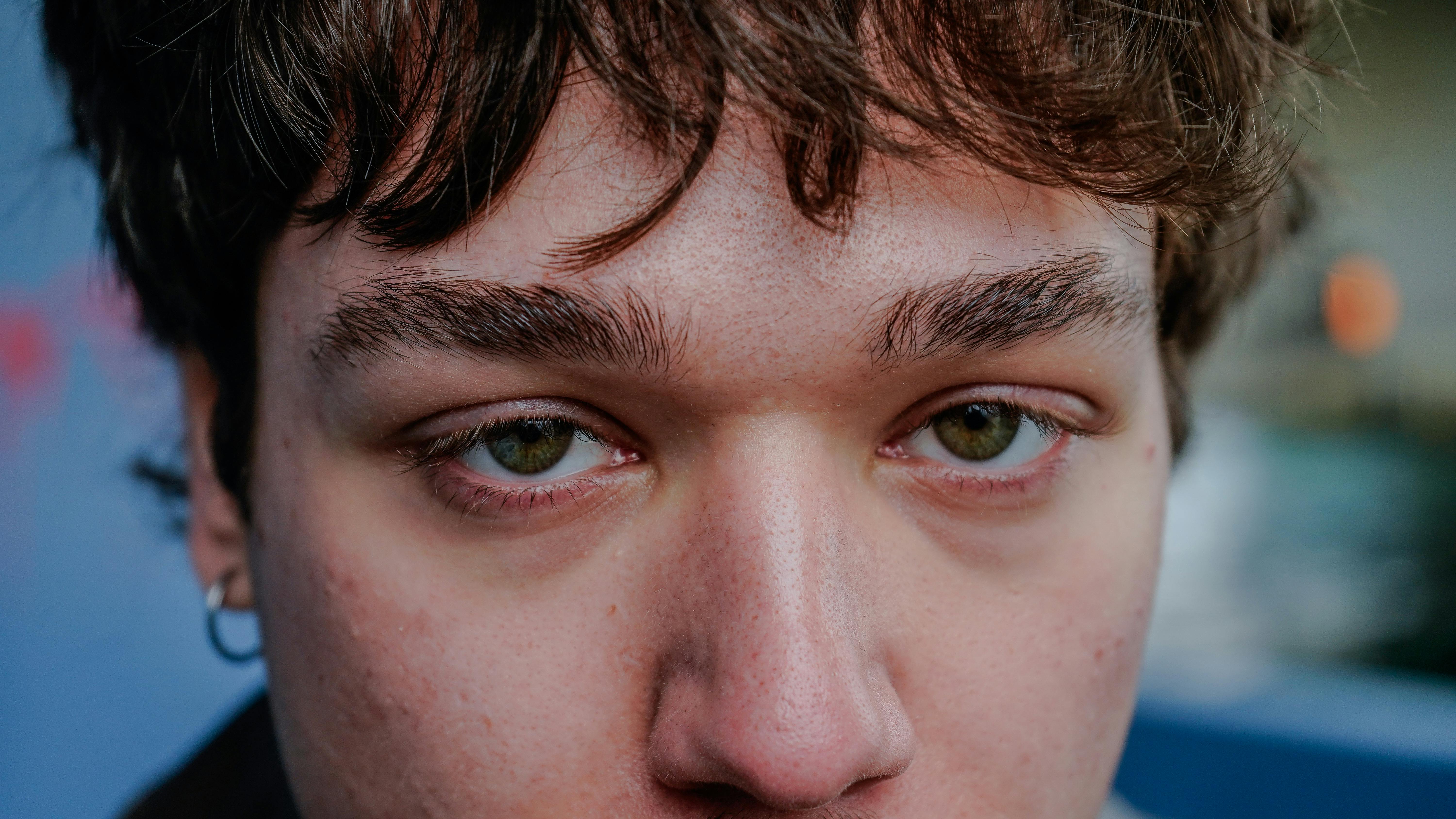 無料 印象的な緑色の目をした若者の若々しい特徴を示す詳細なクローズアップ肖像画。 写真素材