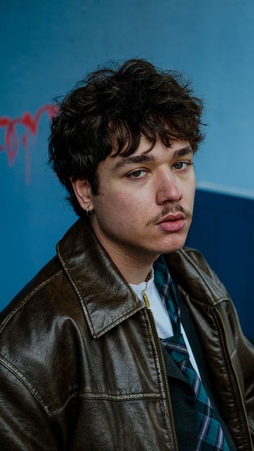 Free A stylish portrait of a young man in a leather jacket, showcasing a modern and edgy look. Stock Photo