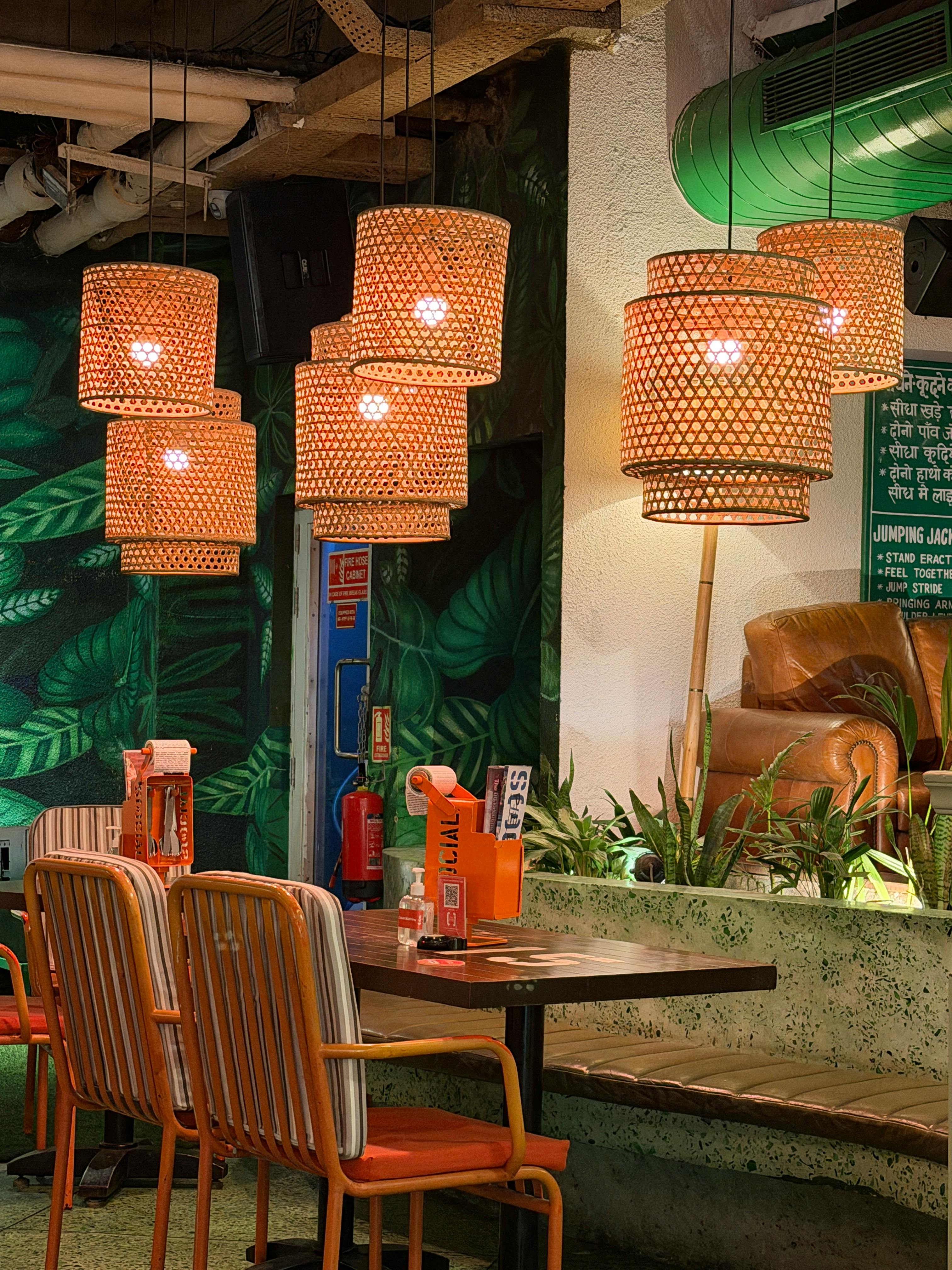 無料 編み込みランプとモダンな装飾が施された、温かみのあるカフェのインテリア。くつろぎのひとときや、社交の場として最適です。 写真素材