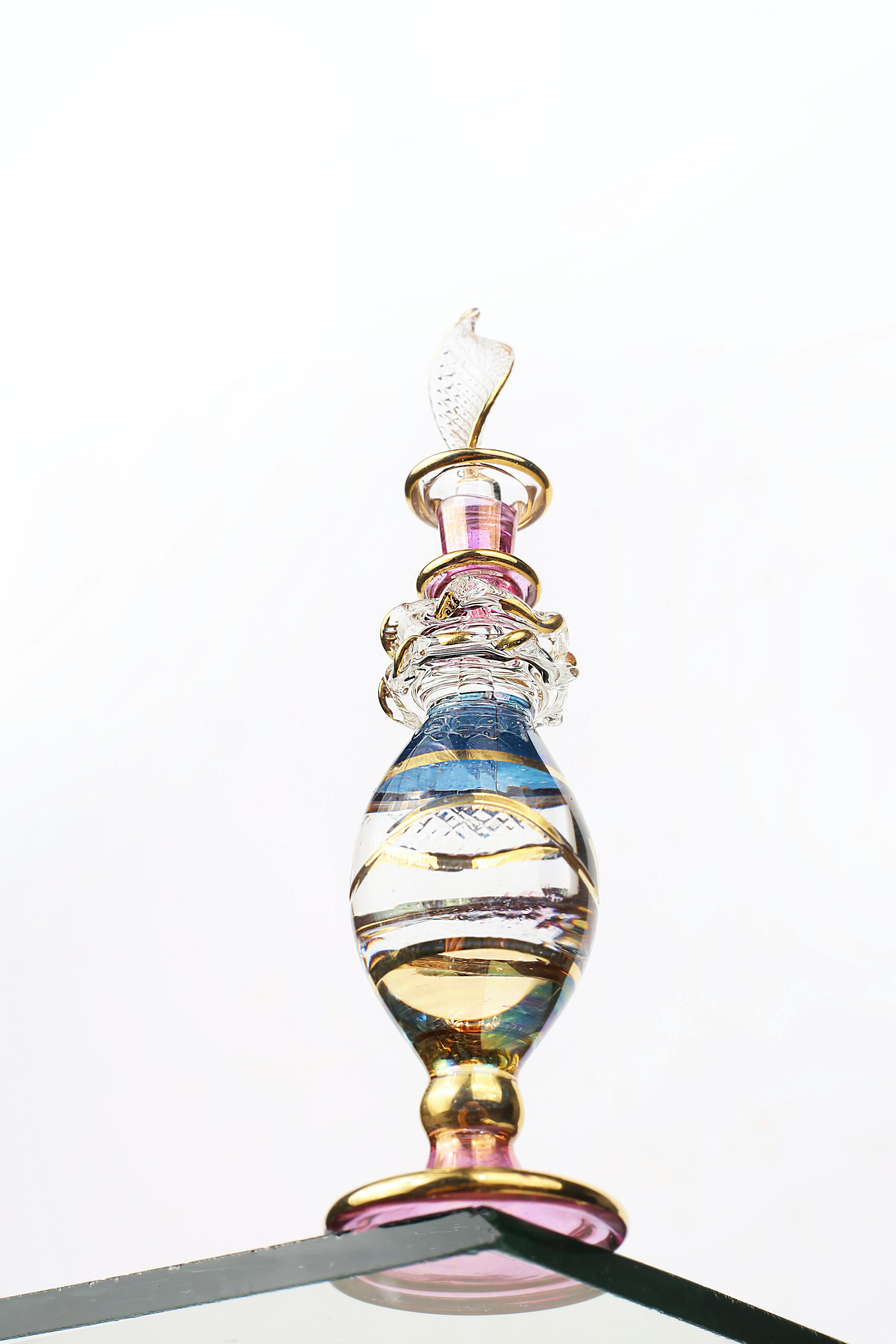 無料 反射面に複雑なデザインを施したエレガントなガラス製香水瓶で、高級感を演出します。 写真素材