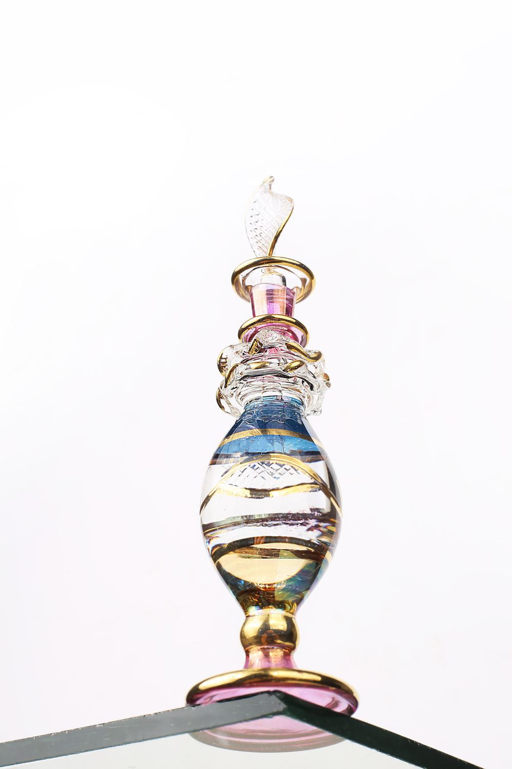 Hand-crafted traditional attar bottle with gold detailing on white