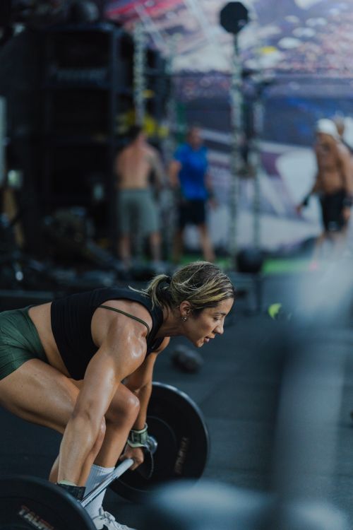 Free Athletic woman lifting weights in a gym, showcasing strength and focus. Stock Photo