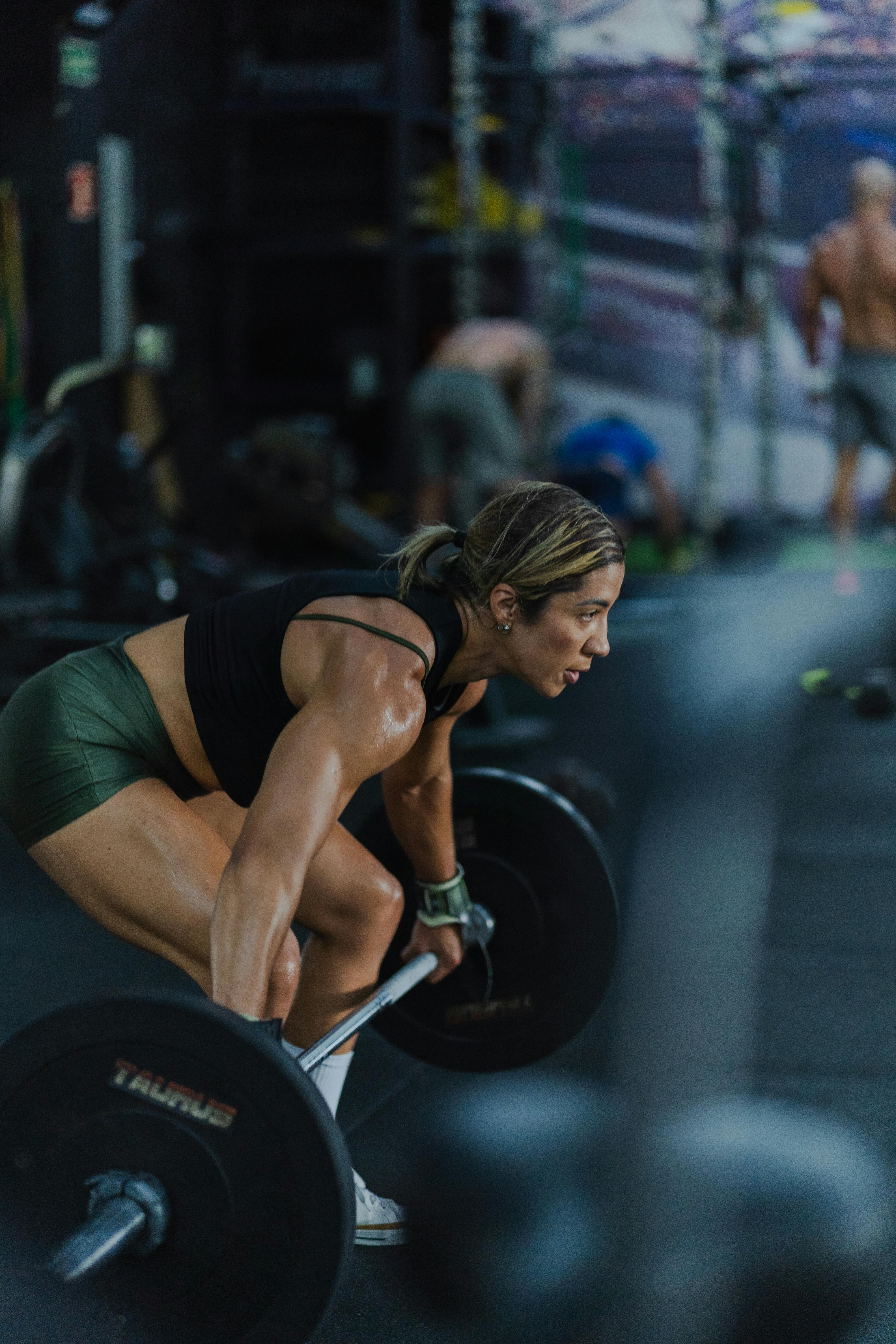 A focused female athlete lifting weights mid-set