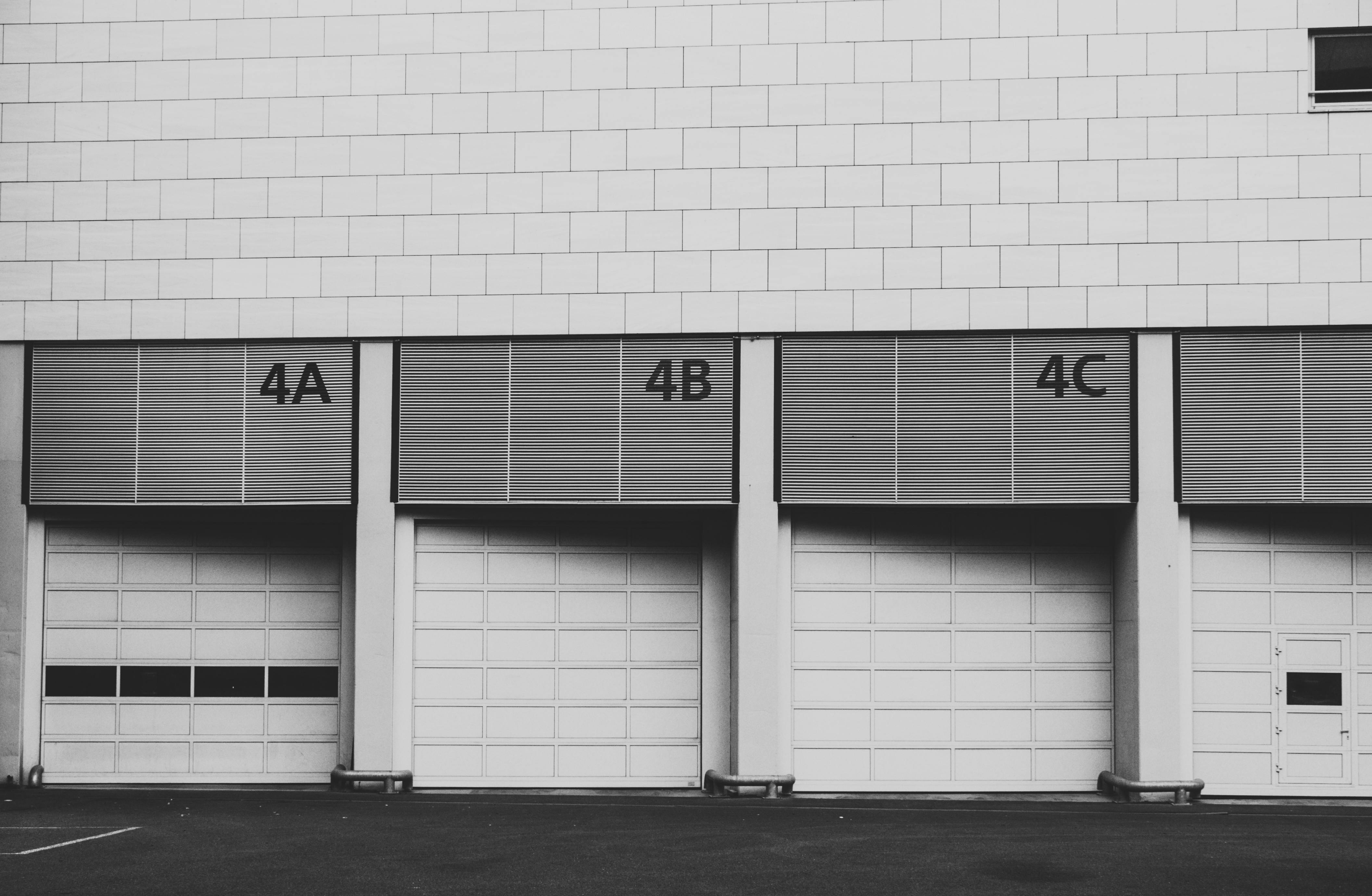 Kostnadsfria Monokrom bild av tre intilliggande industriella lastkajer märkta 4A, 4B, 4C. Stock foto