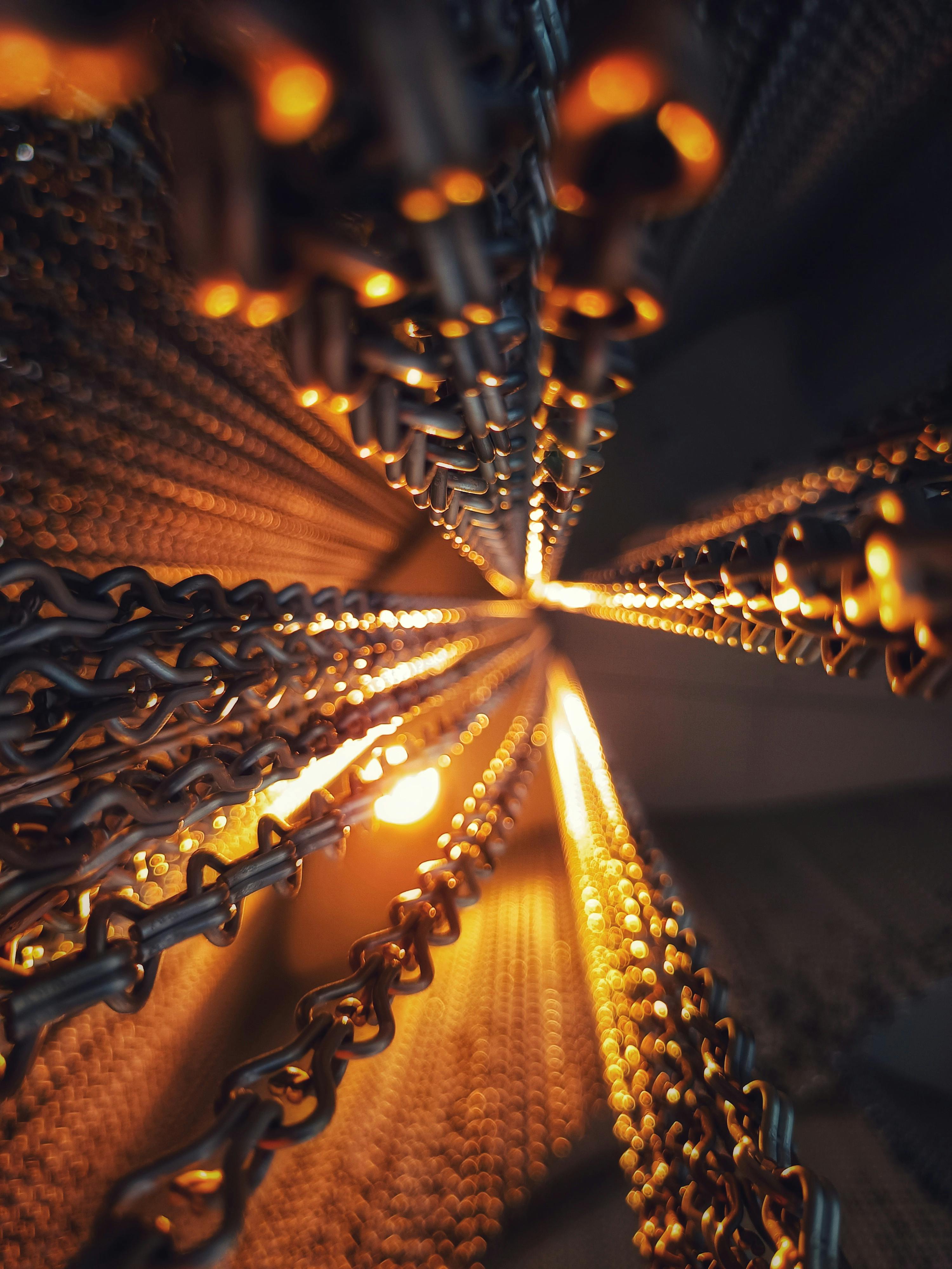 無料 温かみのある光を放つ照明付き金属チェーンのクローズアップ画像。 写真素材