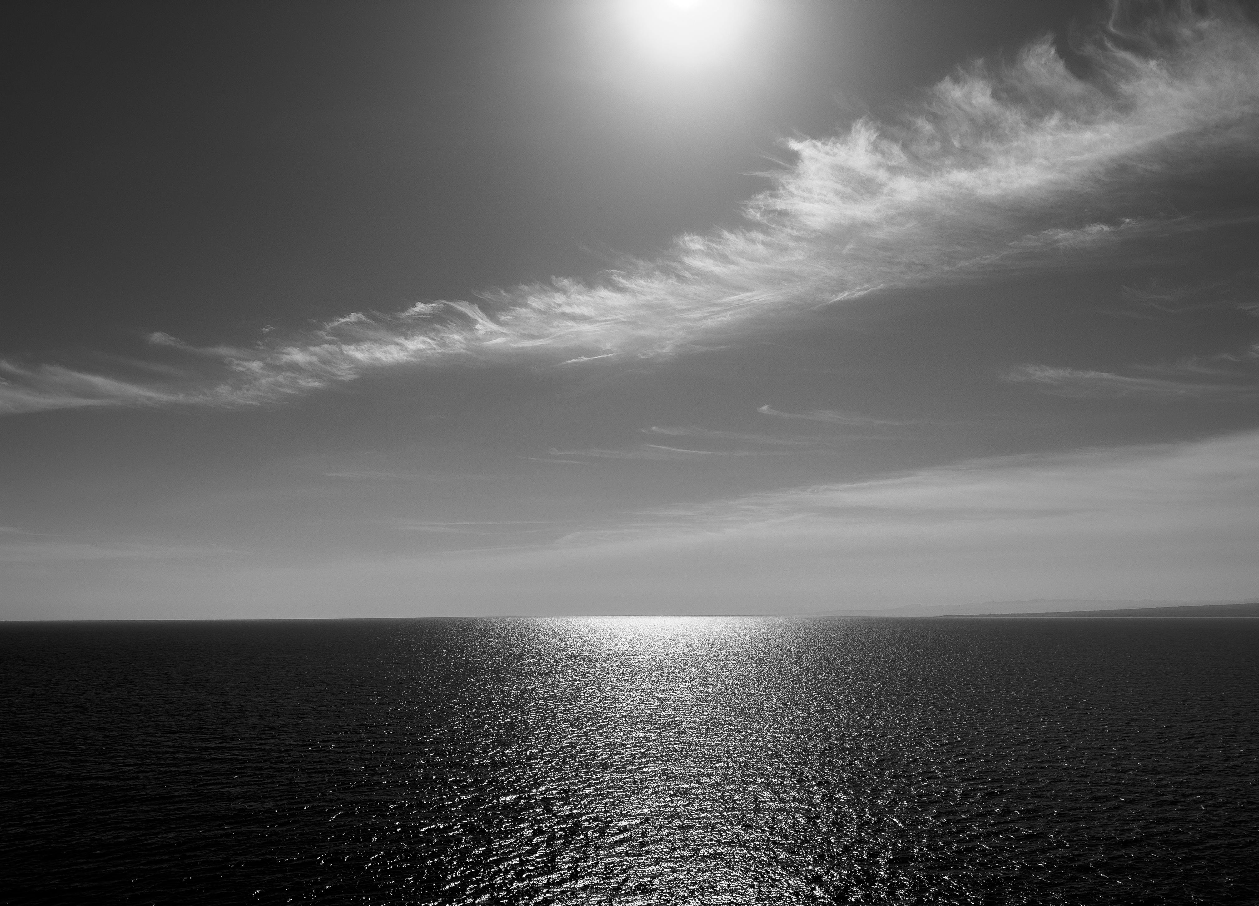 無料 穏やかで静かな、韓国のキラキラ輝く東海に沈む夕日の白黒写真。 写真素材