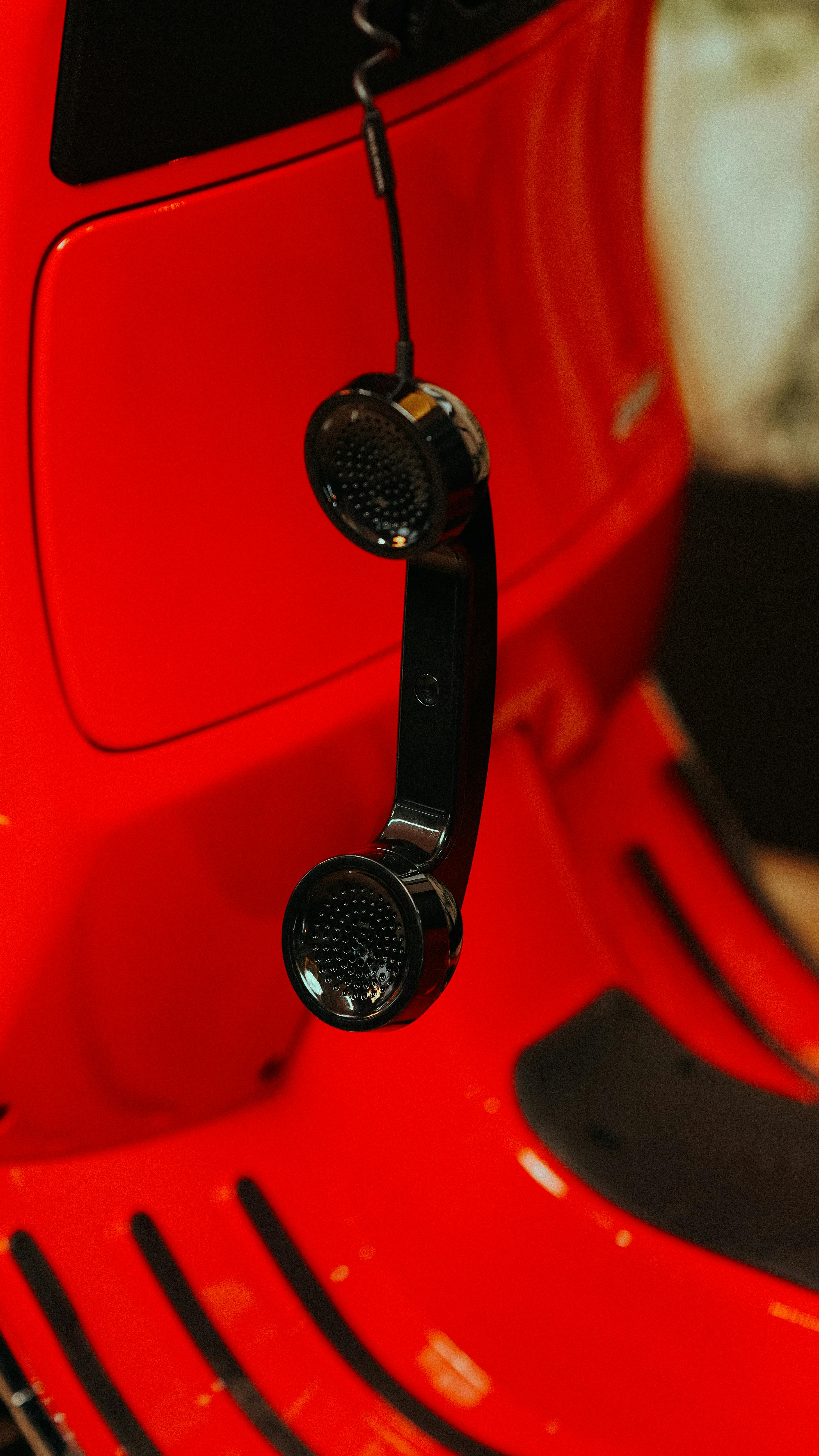 бесплатная Винтажная телефонная трубка, висящая на классическом красном скутере, вызывает ностальгию и сочетает в себе стиль. Стоковое фото