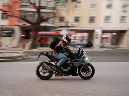 Free Motorcyclist in motion on a city street in Lisbon, Portugal, showcasing urban lifestyle. Stock Photo