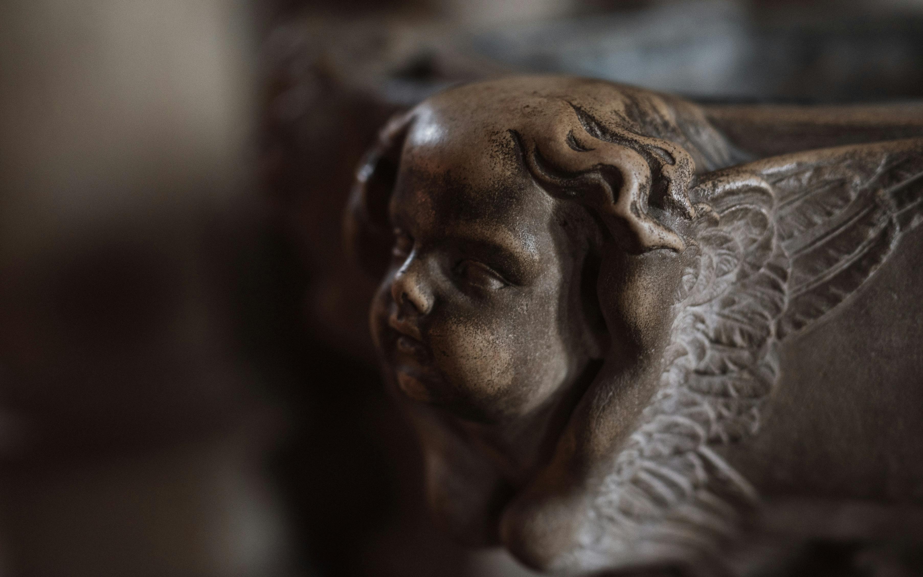 Free Detailed close-up of a vintage cherub sculpture with soft lighting. Stock Photo