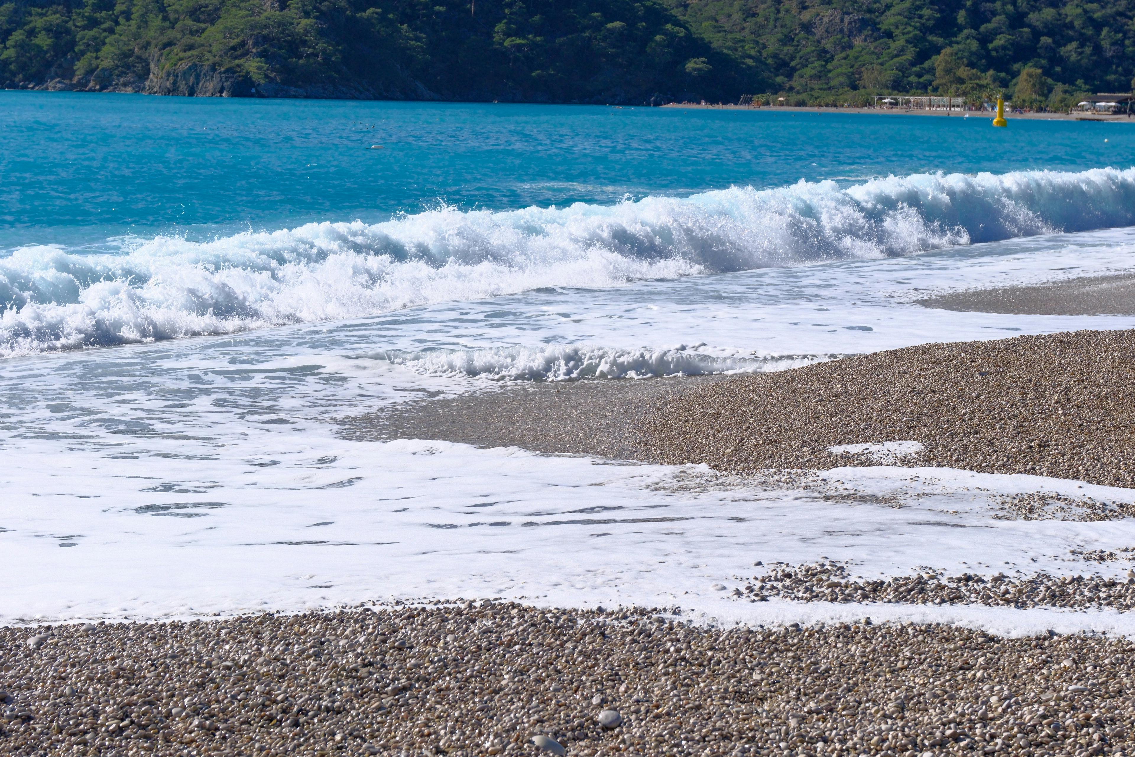 Free Peaceful view of waves crashing on a pebble beach at Ölüdeniz in Türkiye, capturing the beauty of nature. Stock Photo