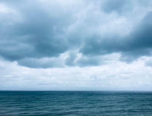 Free Dramatic ocean view with deep blue waves and a stormy, cloudy sky capturing nature's power. Stock Photo