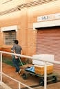 Man Pulling Cart Near Brick Building in Piracicaba