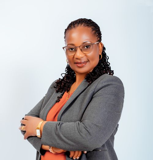 Free Confident woman in glasses, wearing a business suit, smiles with arms crossed. Stock Photo