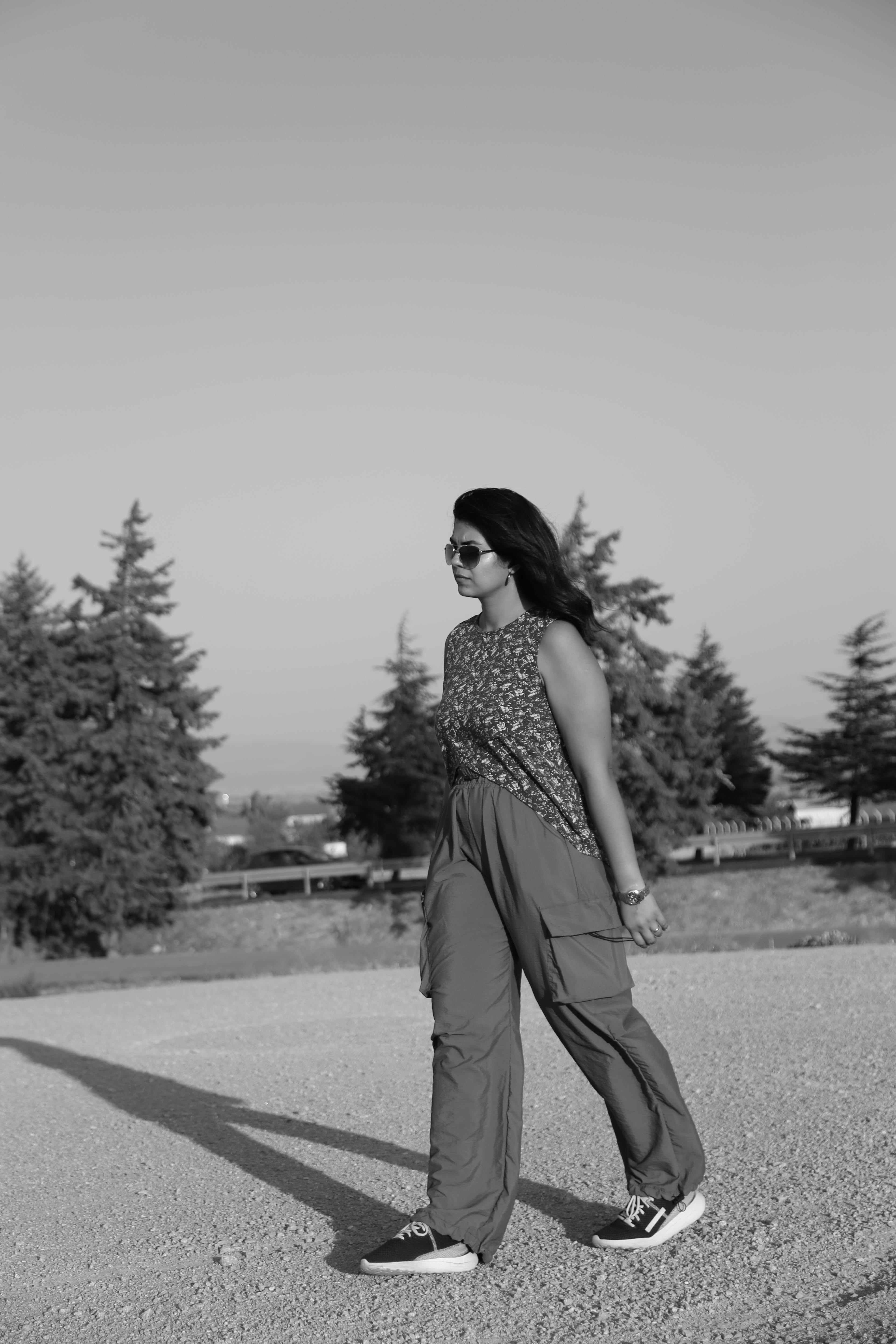 Ücretsiz Sakin bir doğal ortamda yürüyen bir kadının siyah beyaz fotoğrafı. Stok Fotoğraflar